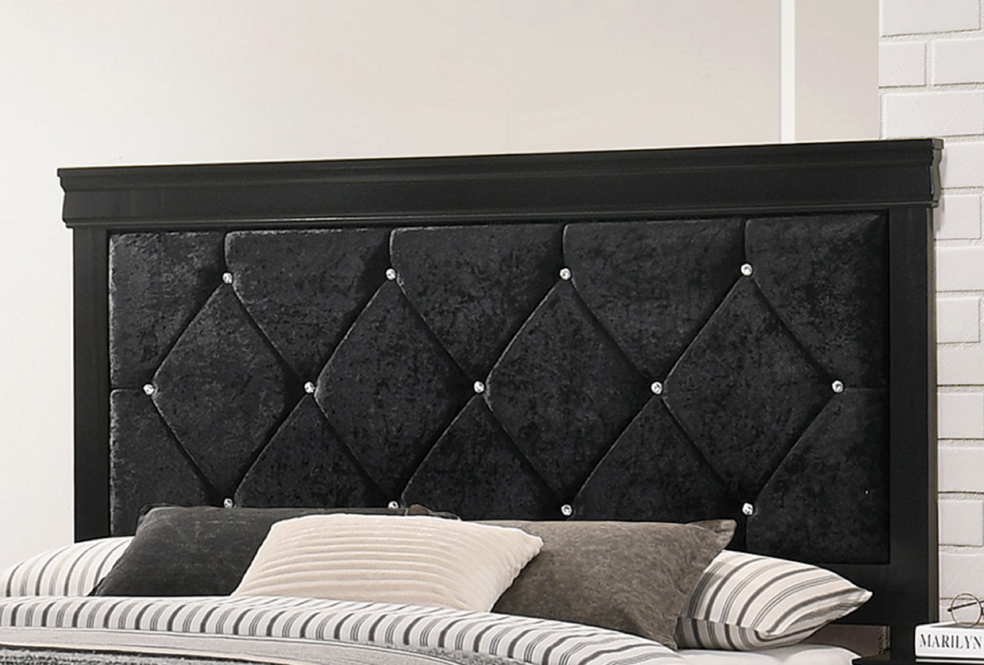 Tufted black velvet headboard with crystal accents on a dark wood frame