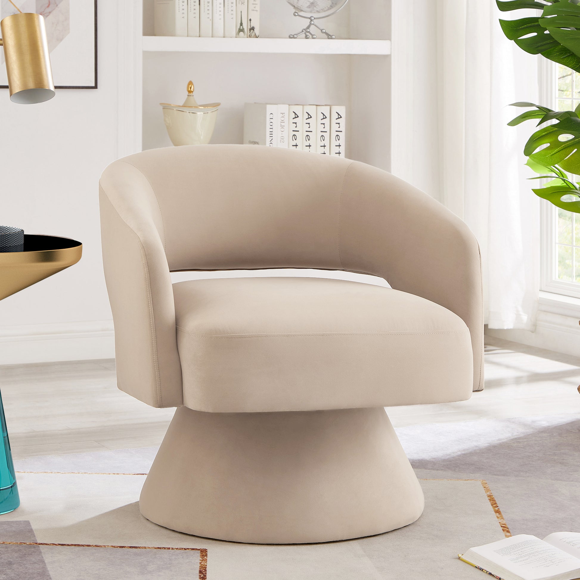 Beige velvet swivel chair with curved back and upholstered pedestal base