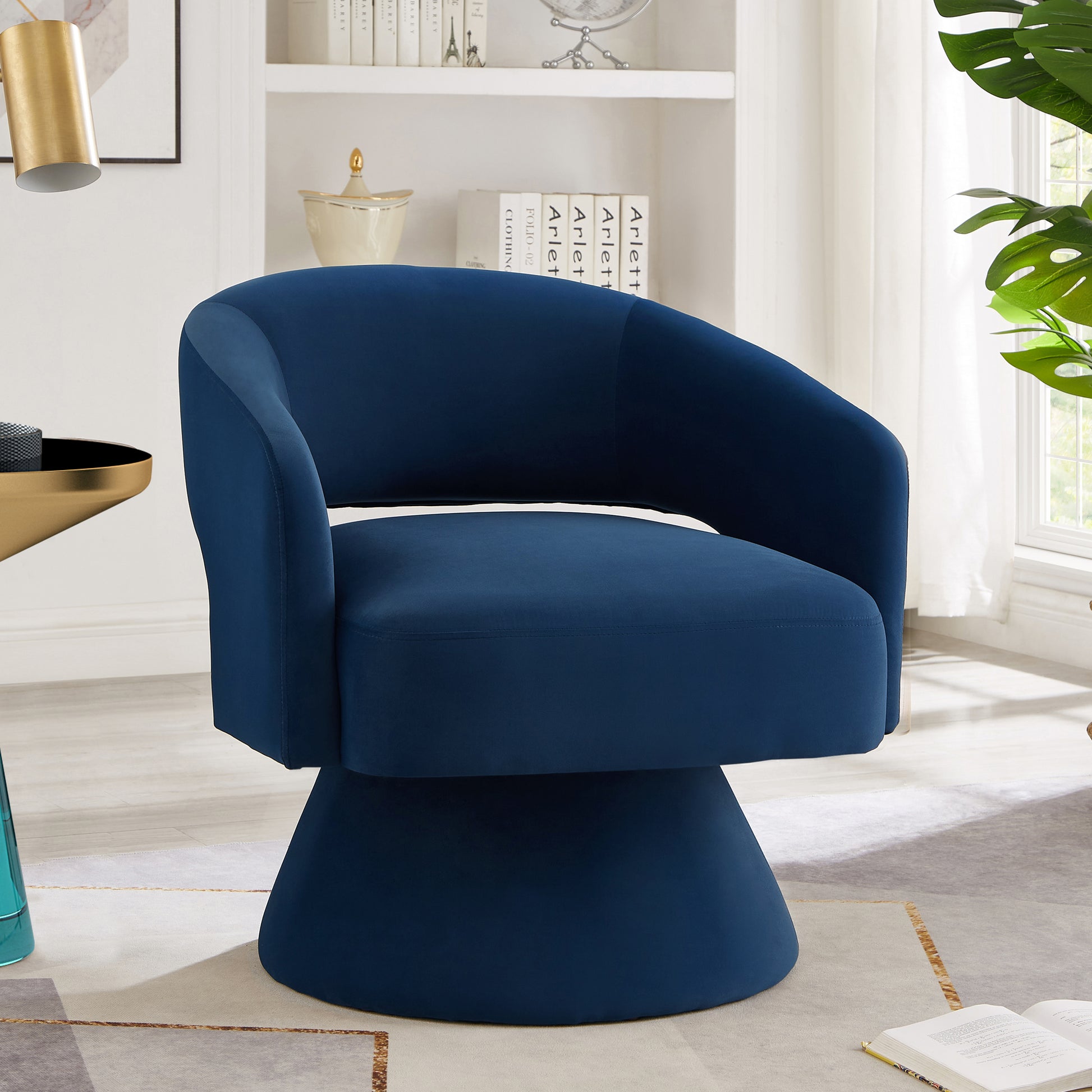 Navy blue velvet swivel chair with a flared base perfect for a modern living room accent