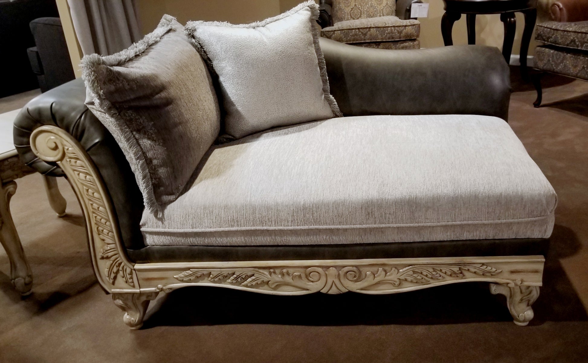 Elegant chaise lounge with ornate carved wood frame and plush fabric upholstery