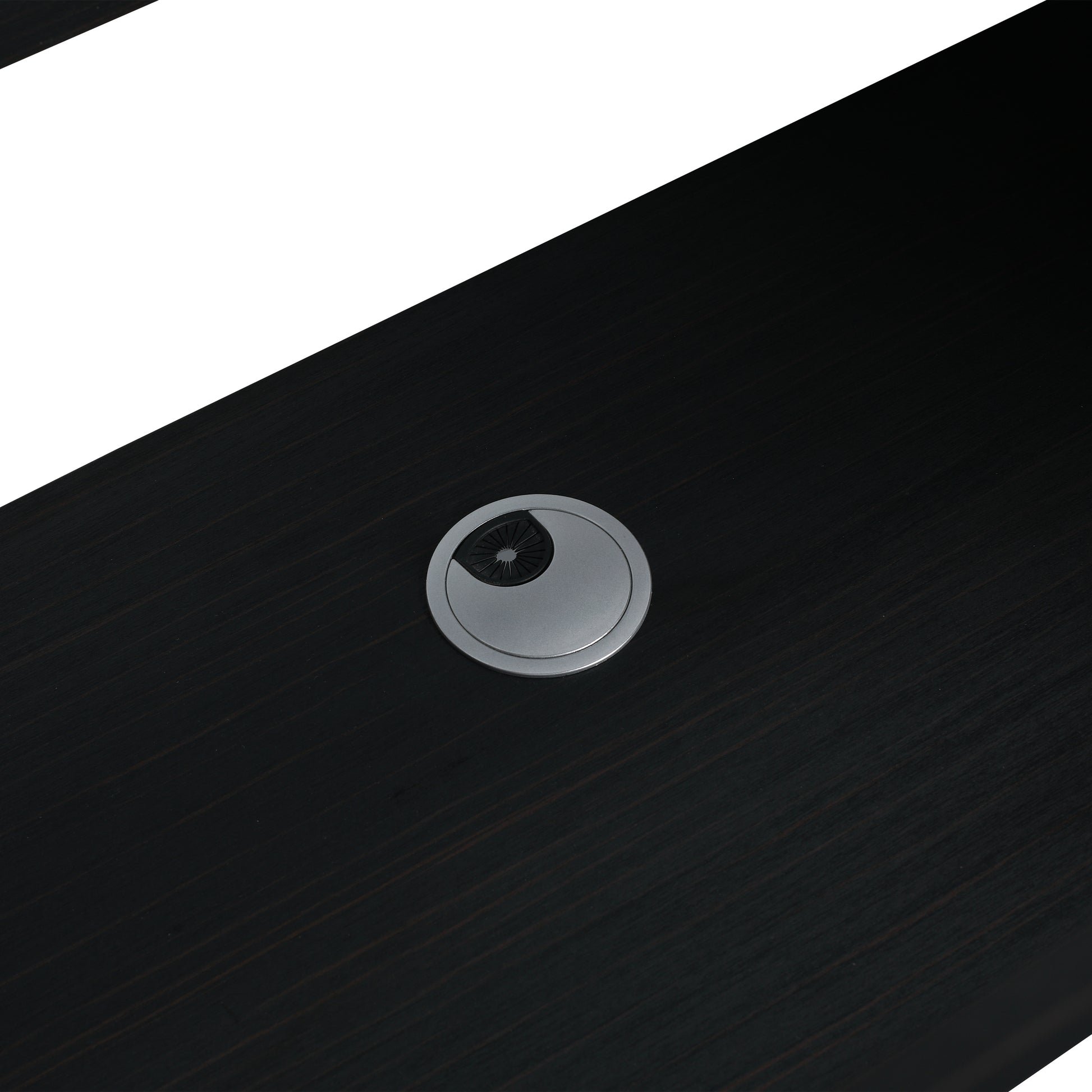 Dark wood desk surface with a sleek silver grommet for cable management