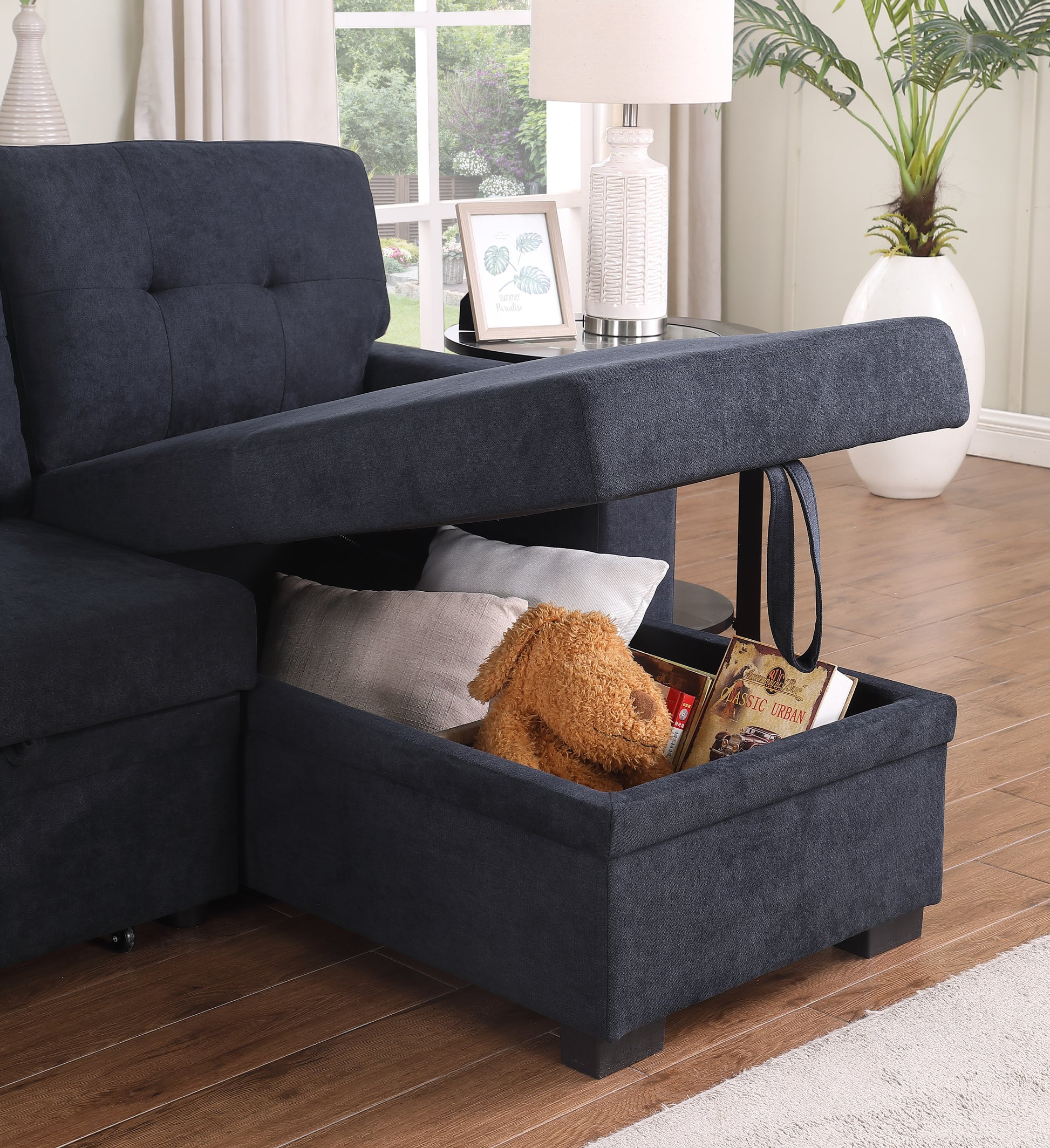 Dark blue fabric sectional sofa with hidden storage compartment open revealing pillows and books