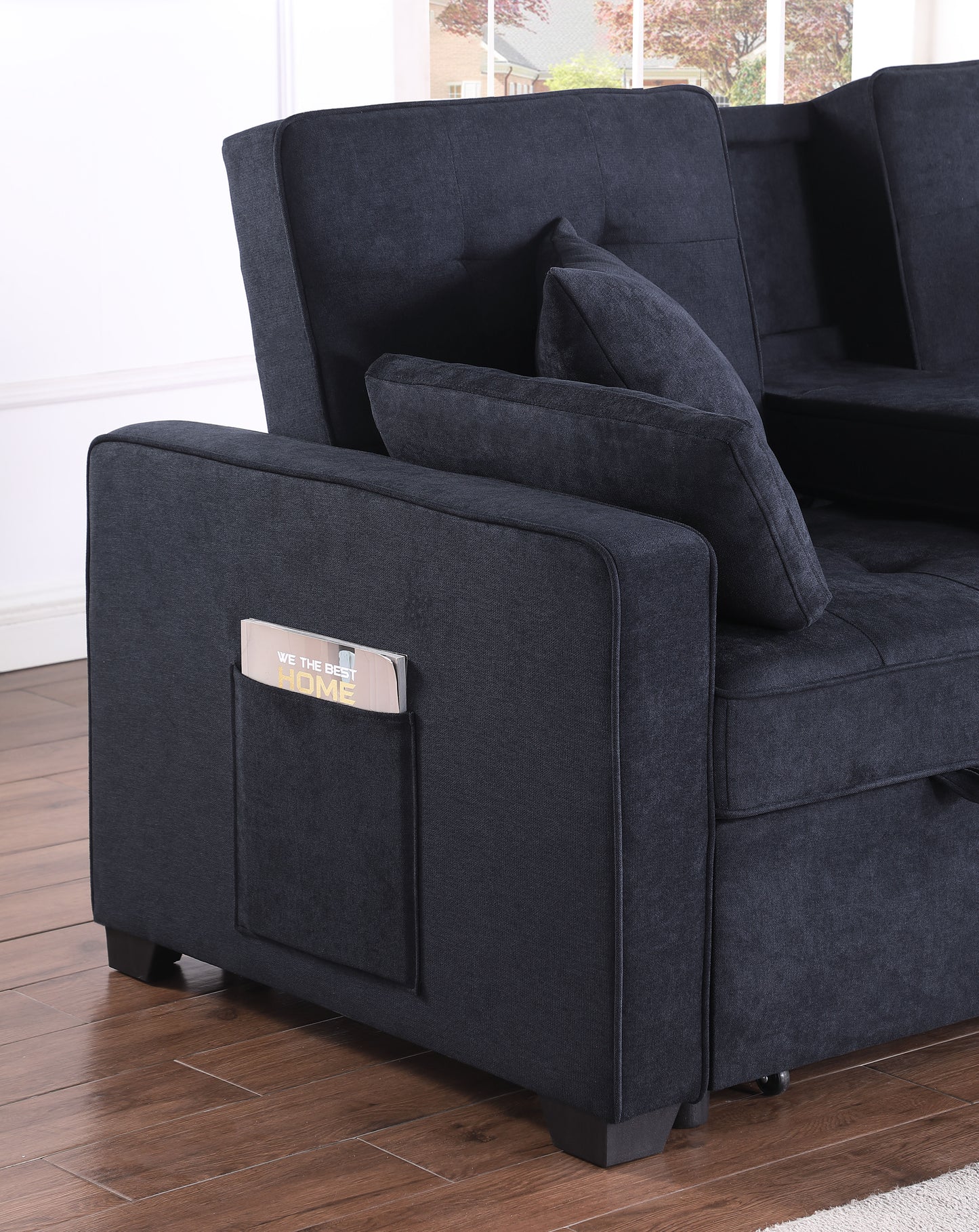 Dark navy upholstered sofa with side pocket holding a magazine for easy access