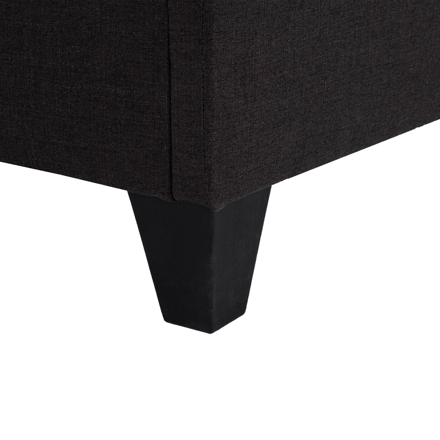 Dark gray textured fabric sofa corner with a tapered black wooden leg