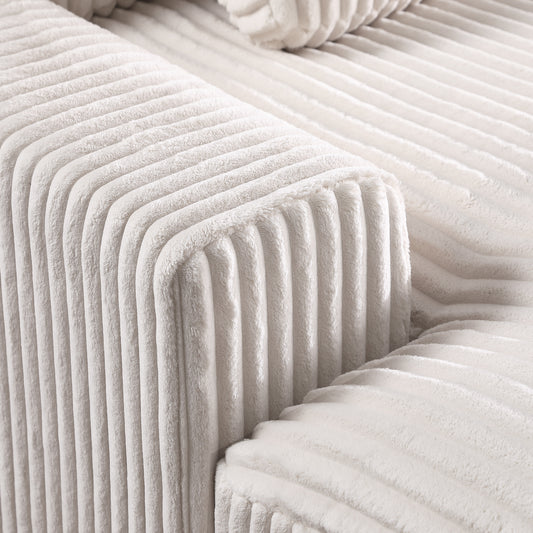 Closeup of soft ivory corduroy fabric texture on a plush sofa armrest