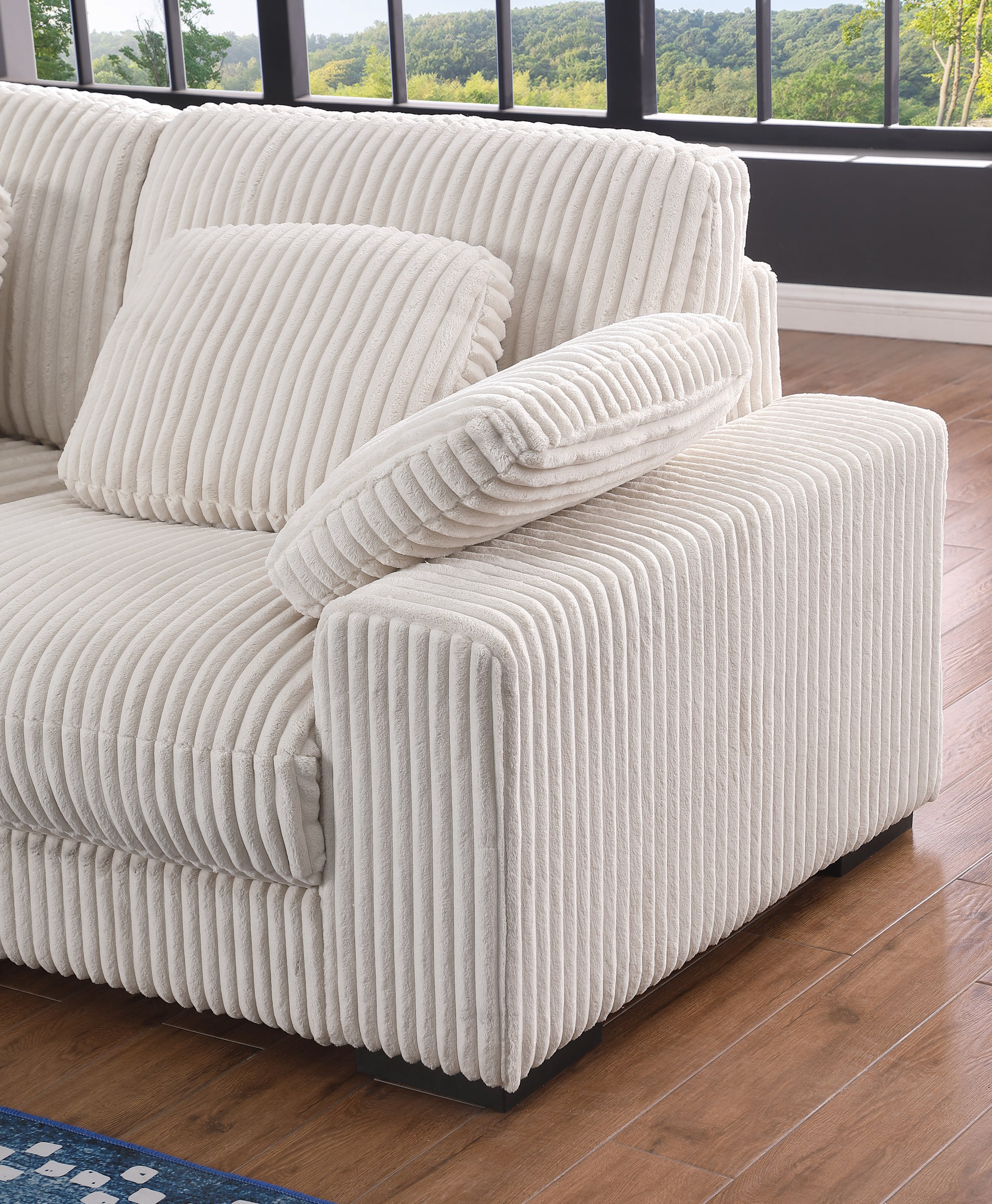 Cream corduroy sofa with plush cushions and vertical ribbing creating a cozy living room feel