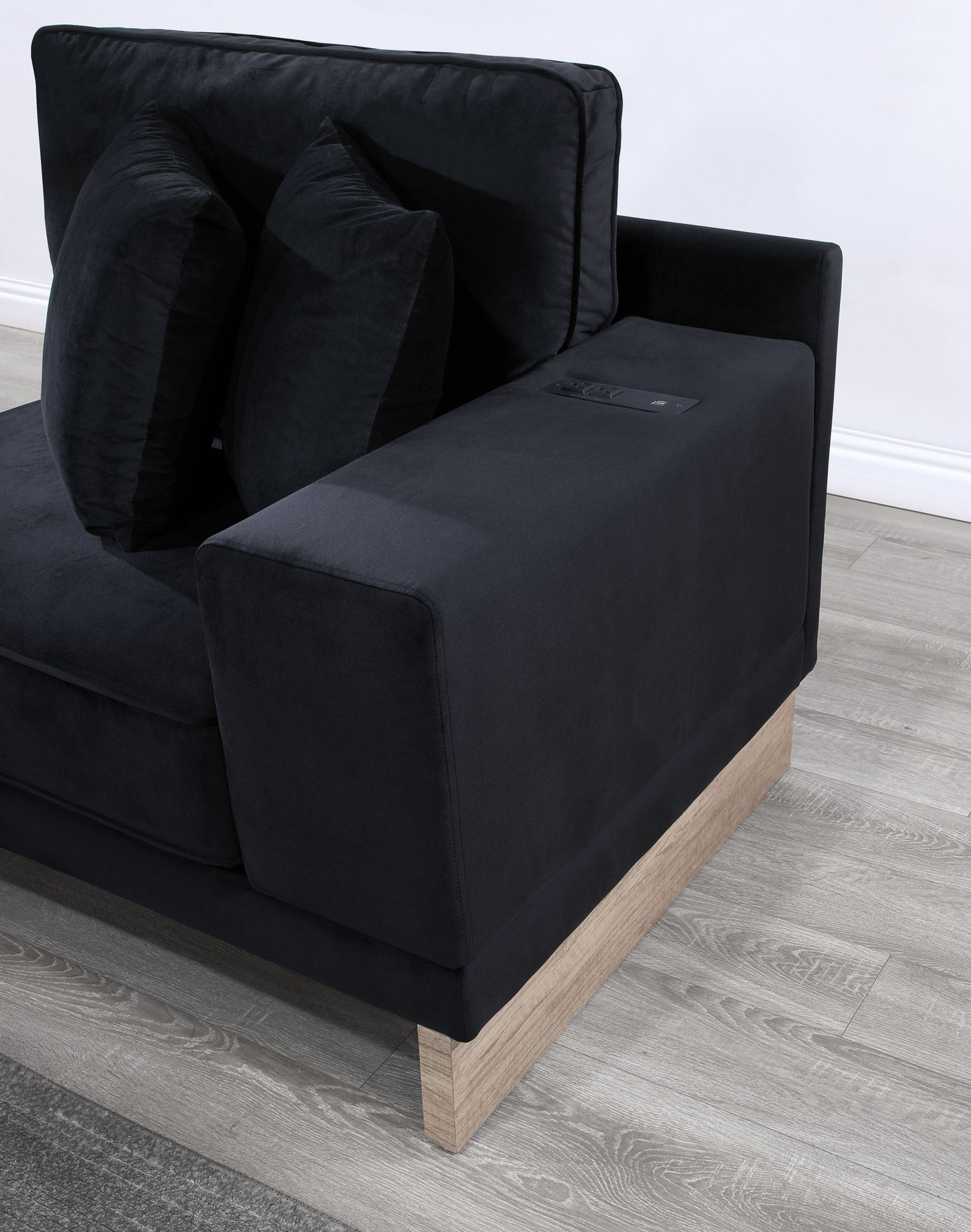 Luxurious black velvet sofa with integrated charging station and modern wood base