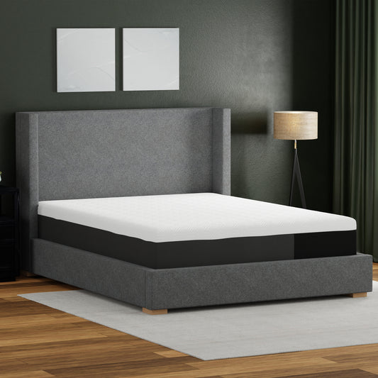 White and charcoal queen memory foam mattress on a grey upholstered bed frame