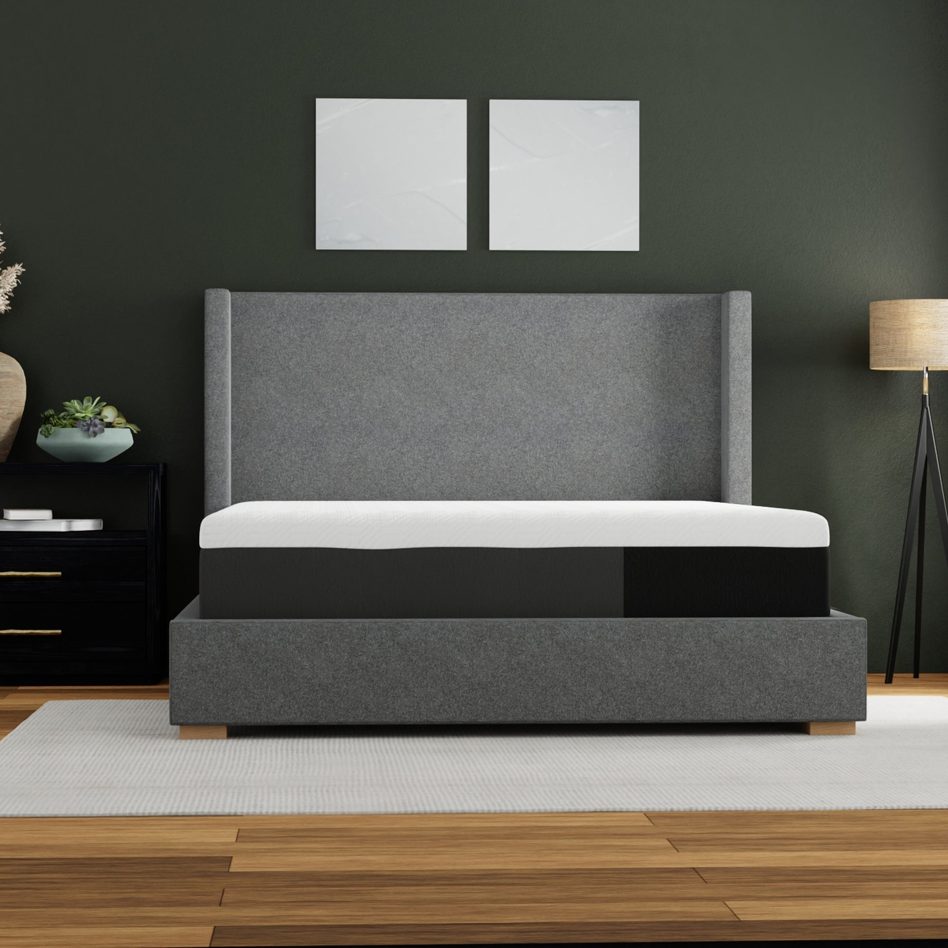 Gray upholstered bed frame with white and black mattress on platform base