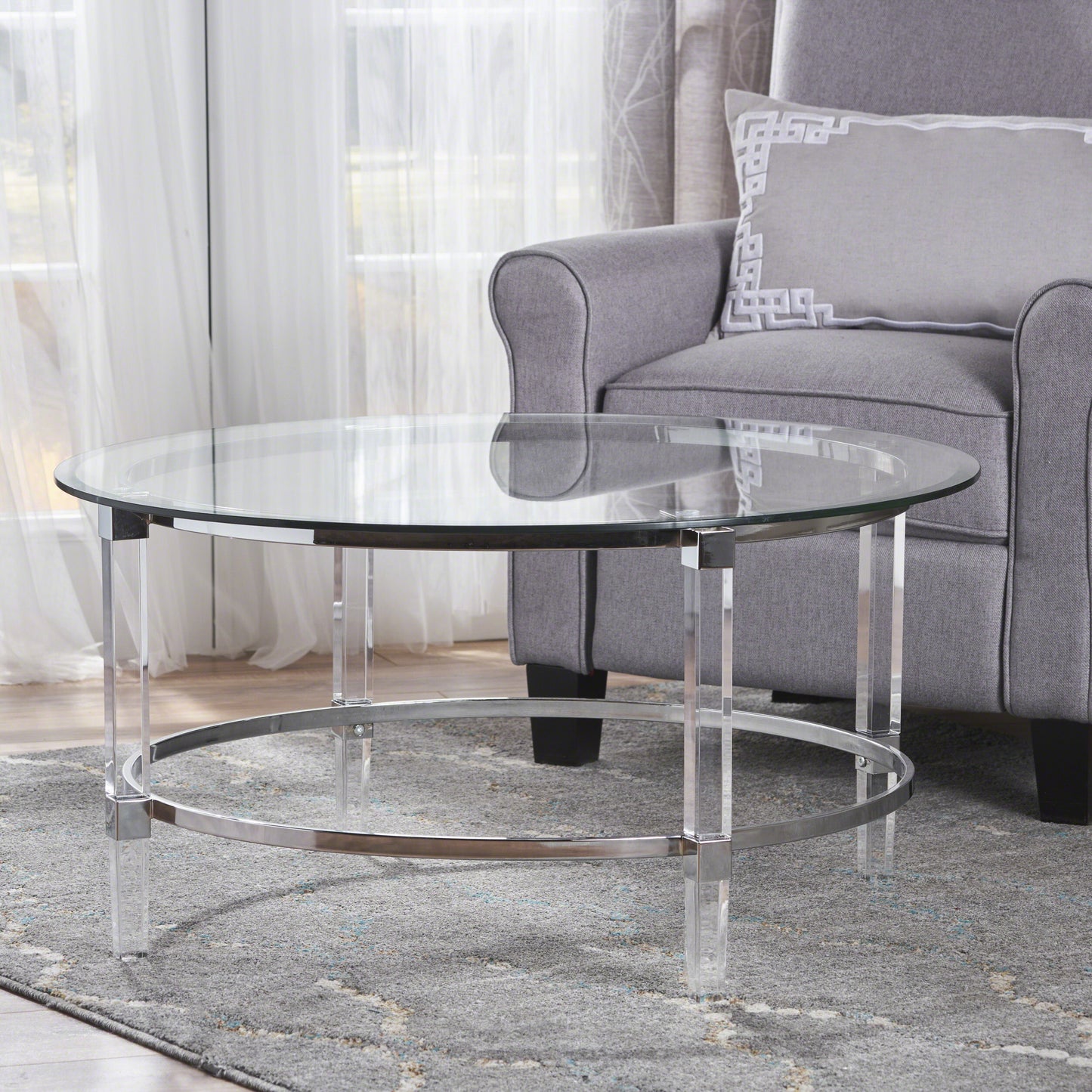 Clear glass round coffee table with acrylic legs and chrome accents