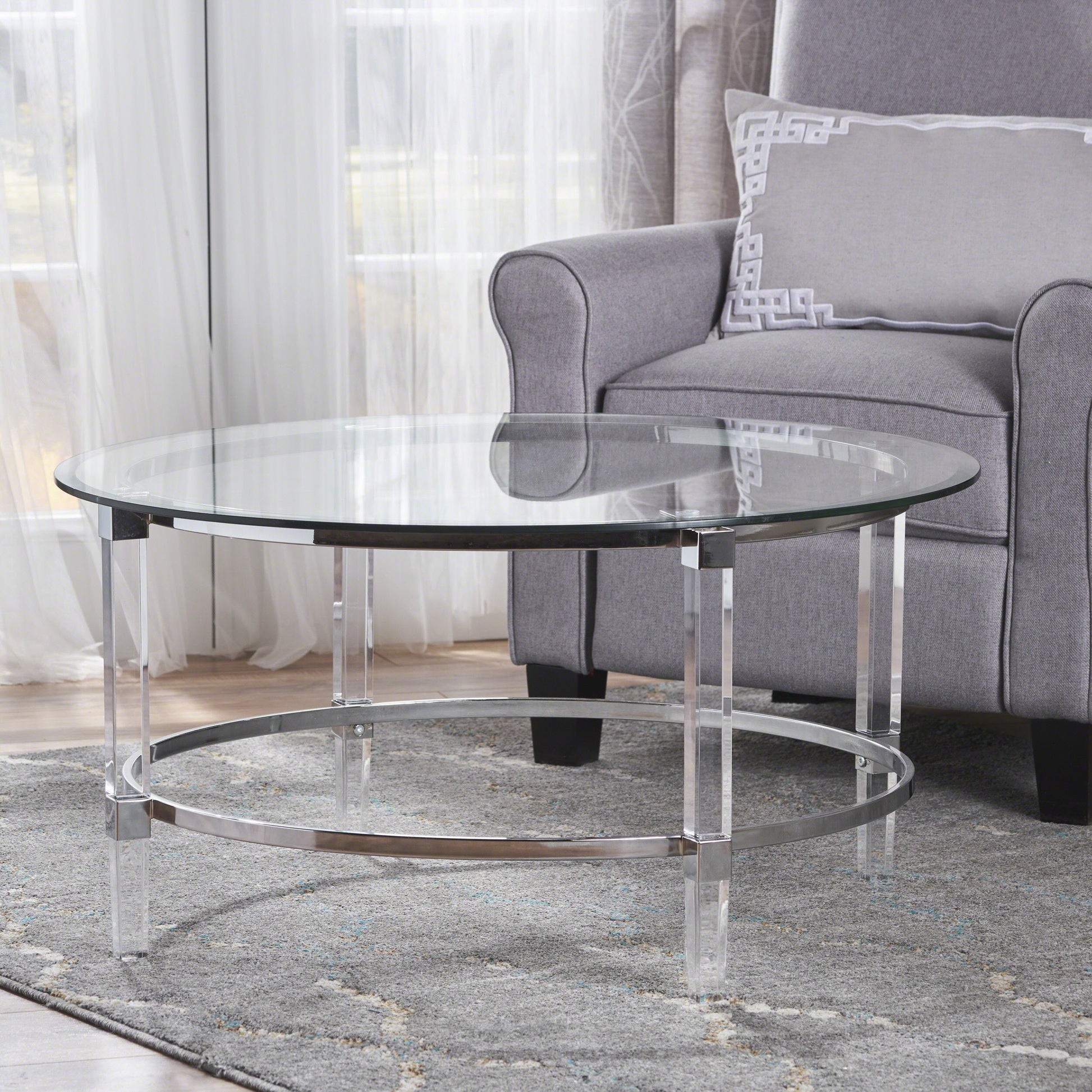 Clear glass round coffee table with acrylic legs and chrome accents