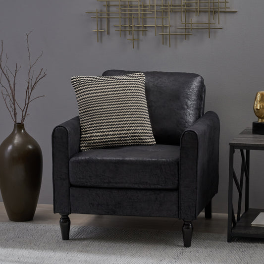 Black faux leather armchair with a textured knit throw pillow and dark wooden legs