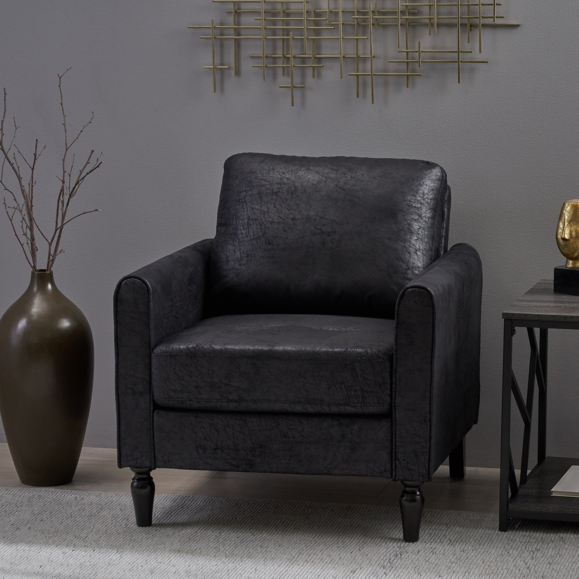 Black faux leather accent chair with rolled arms and plush cushioning
