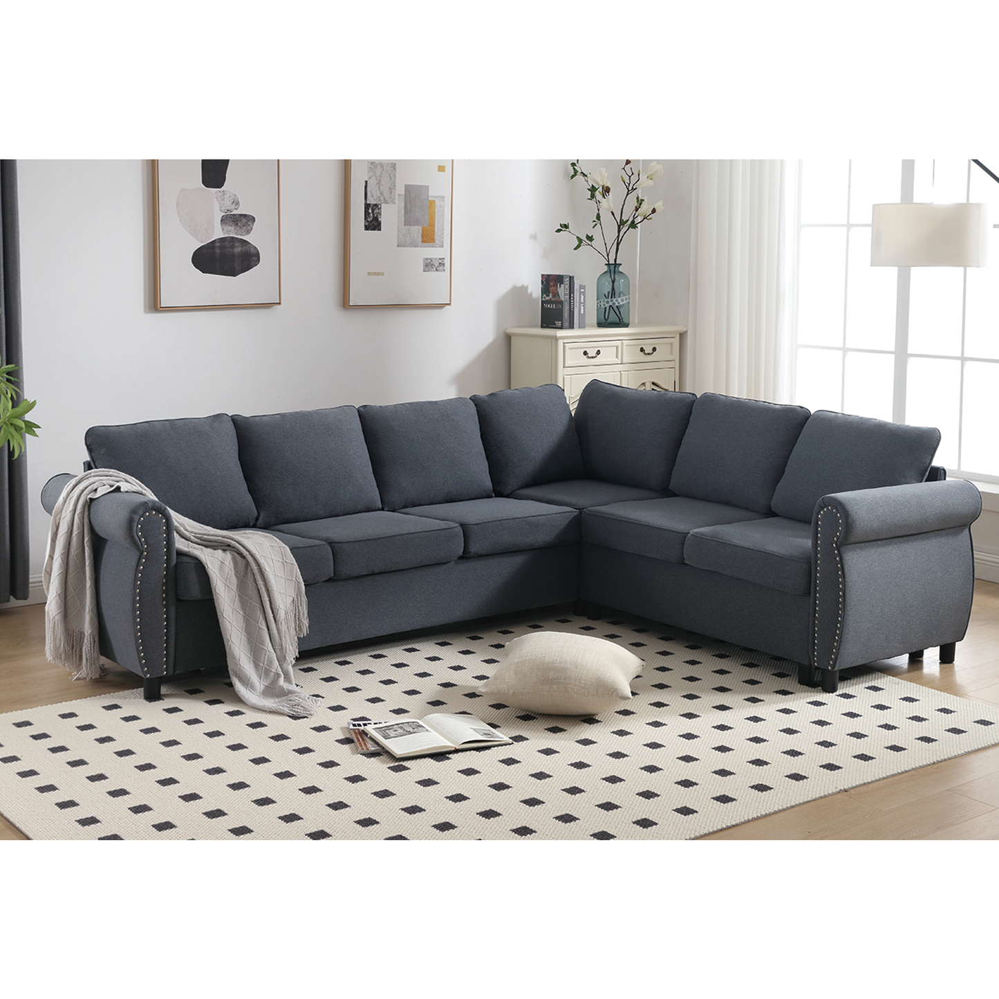 Dark blue fabric sectional sofa with rolled arms and decorative nailhead trim