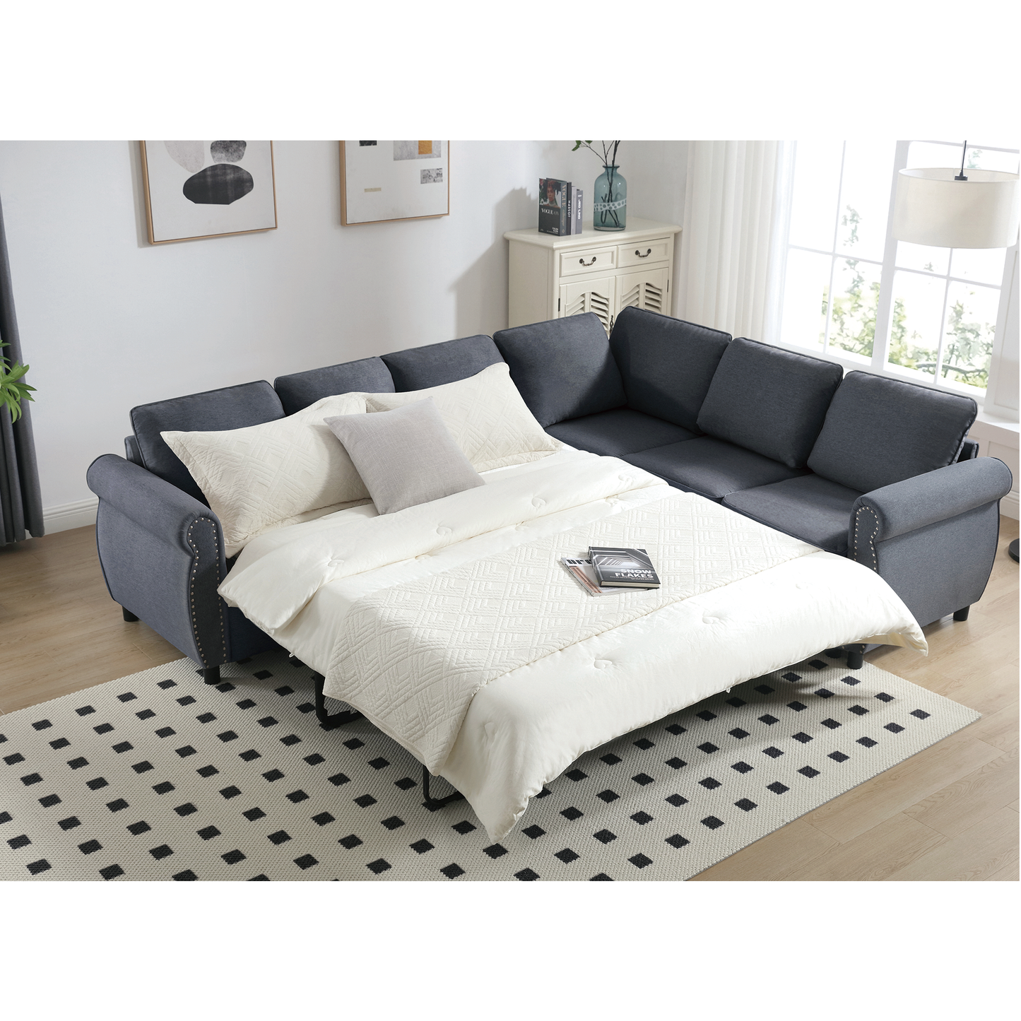 Dark gray sectional sofa bed with tufted details and a pullout mattress in a modern living room setting