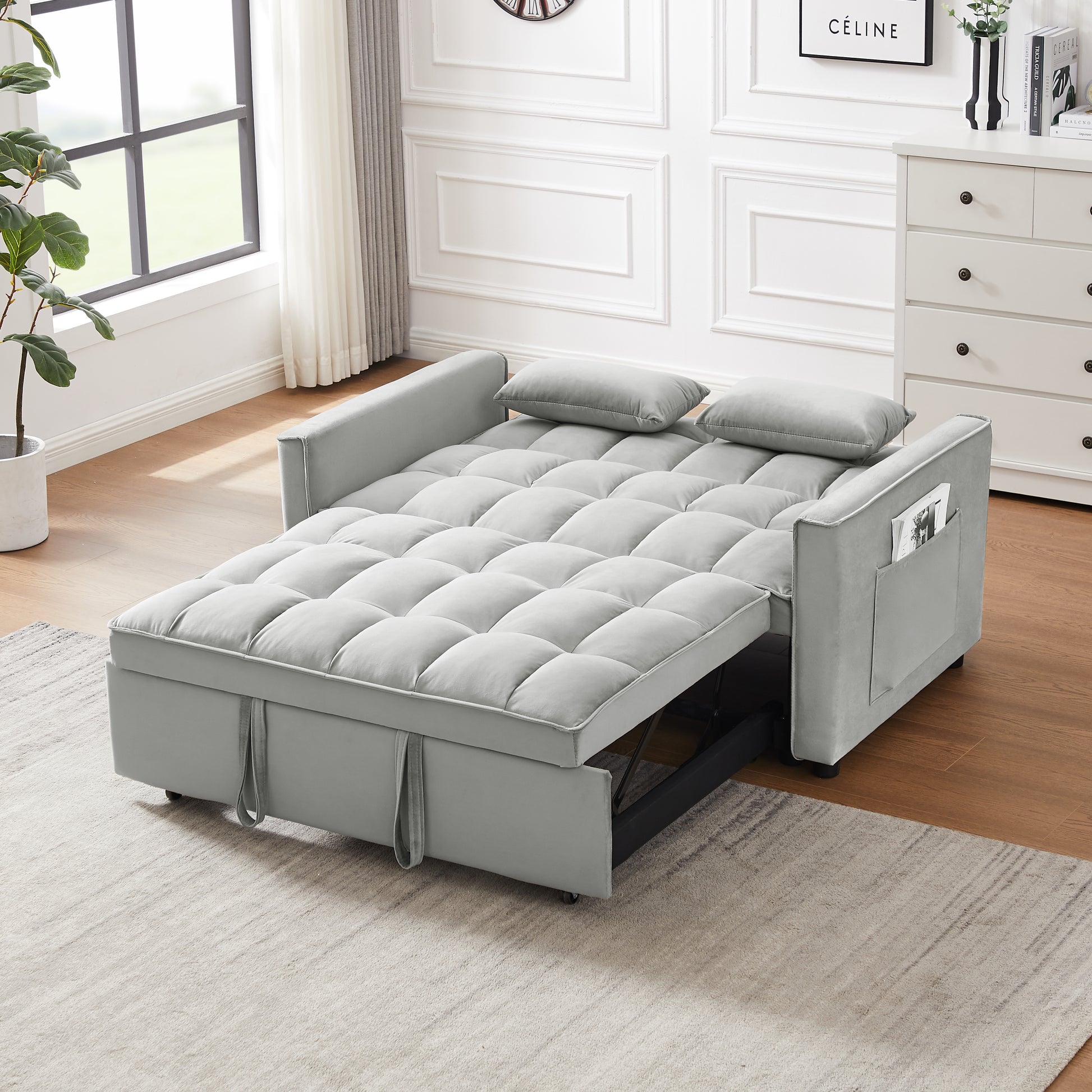 Grey velvet sofa bed with tufted cushions and side storage pocket