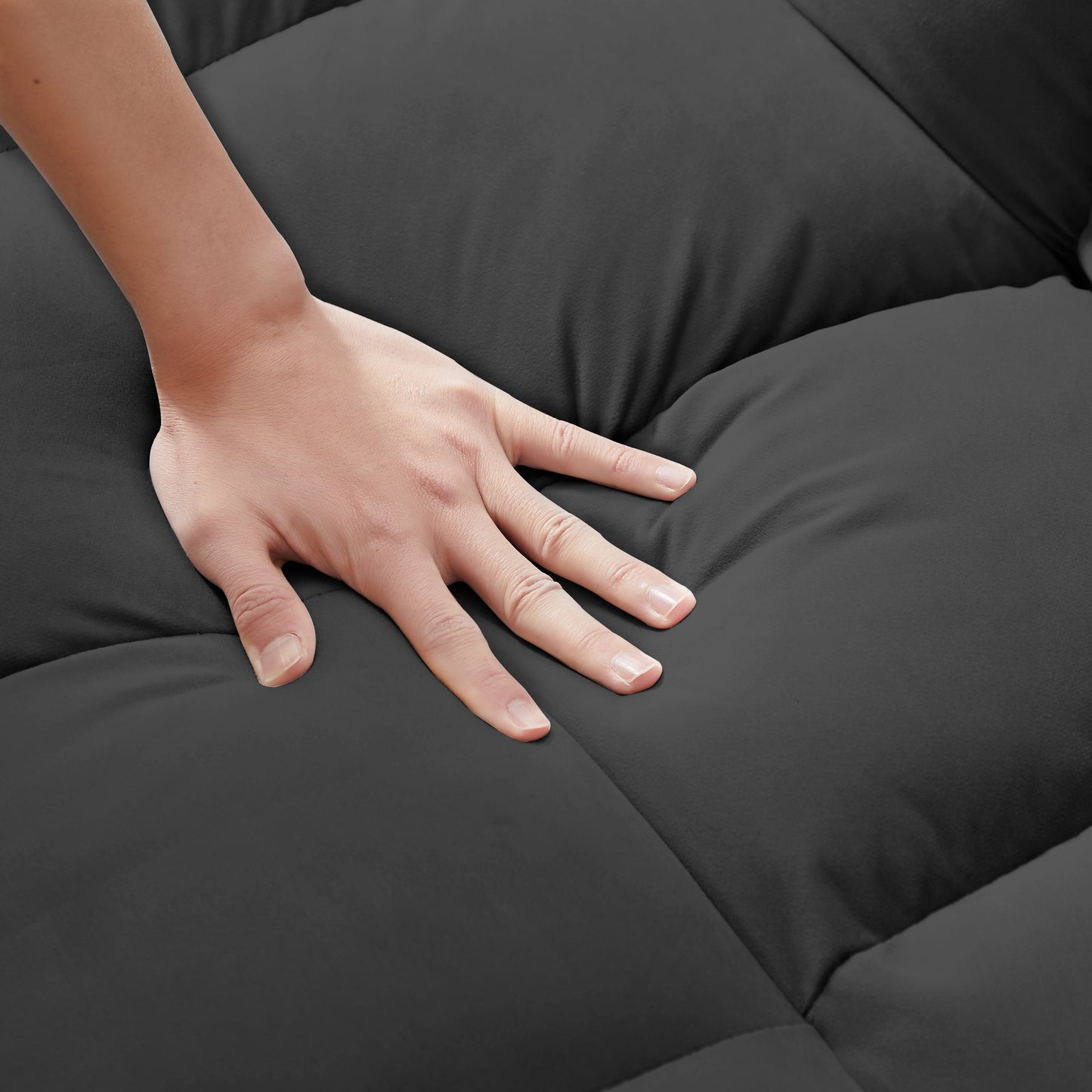 Close up of hand pressing into soft dark gray plush blanket highlighting cozy comfort