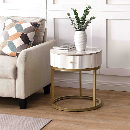 White fluted round side table with gold base and marble top next to sofa