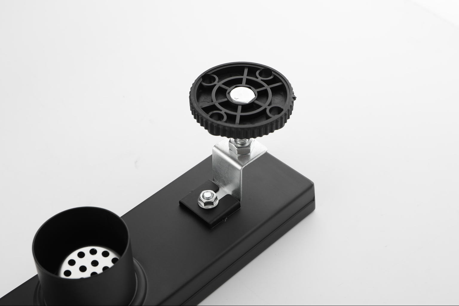 Black adjustable knob on a metal bracket attached to a black electronic device