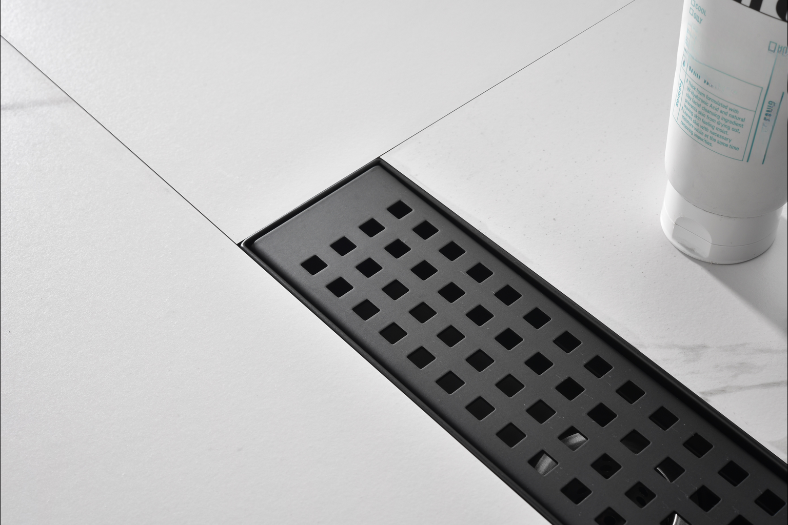 Modern black linear shower drain with textured tiling