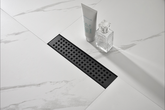 Black linear shower drain with a modern square pattern on a marblelook tile floor
