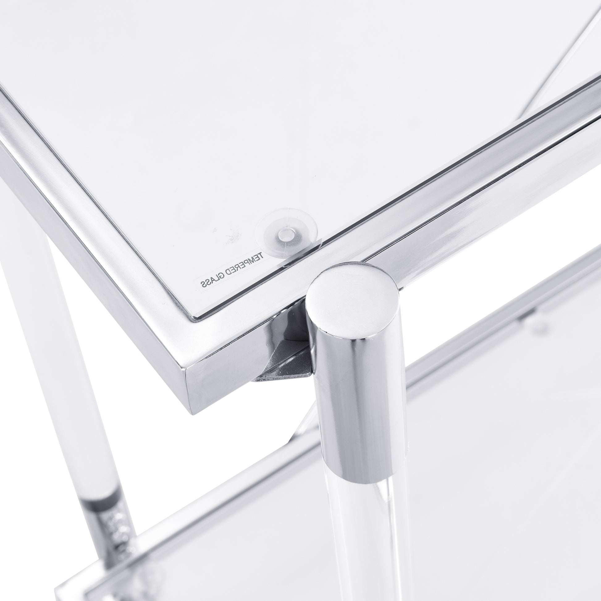 Closeup of a clear tempered glass tabletop with chrome accents part of a stylish accent table