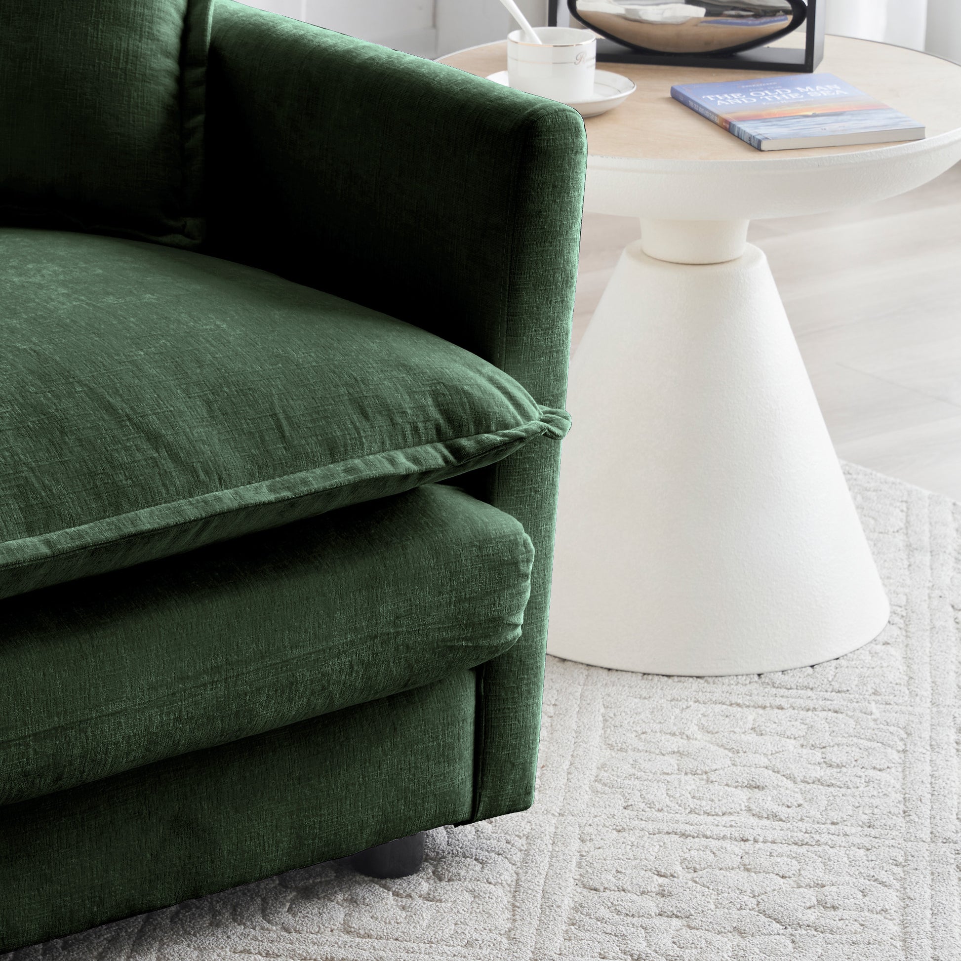 Deep green textured fabric armchair with plush cushions