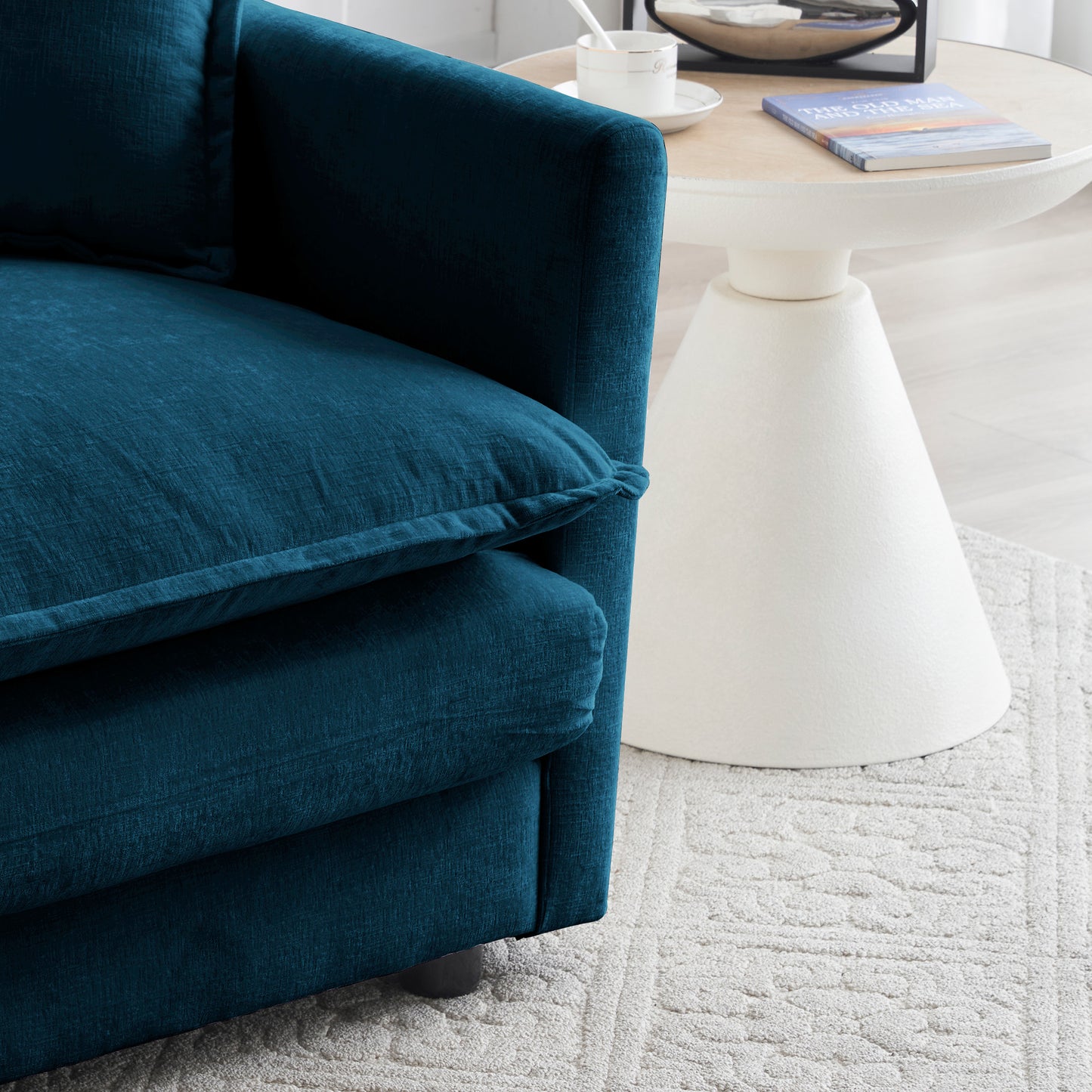 Closeup of a plush teal velvet armchair with textured fabric and comfortable cushions
