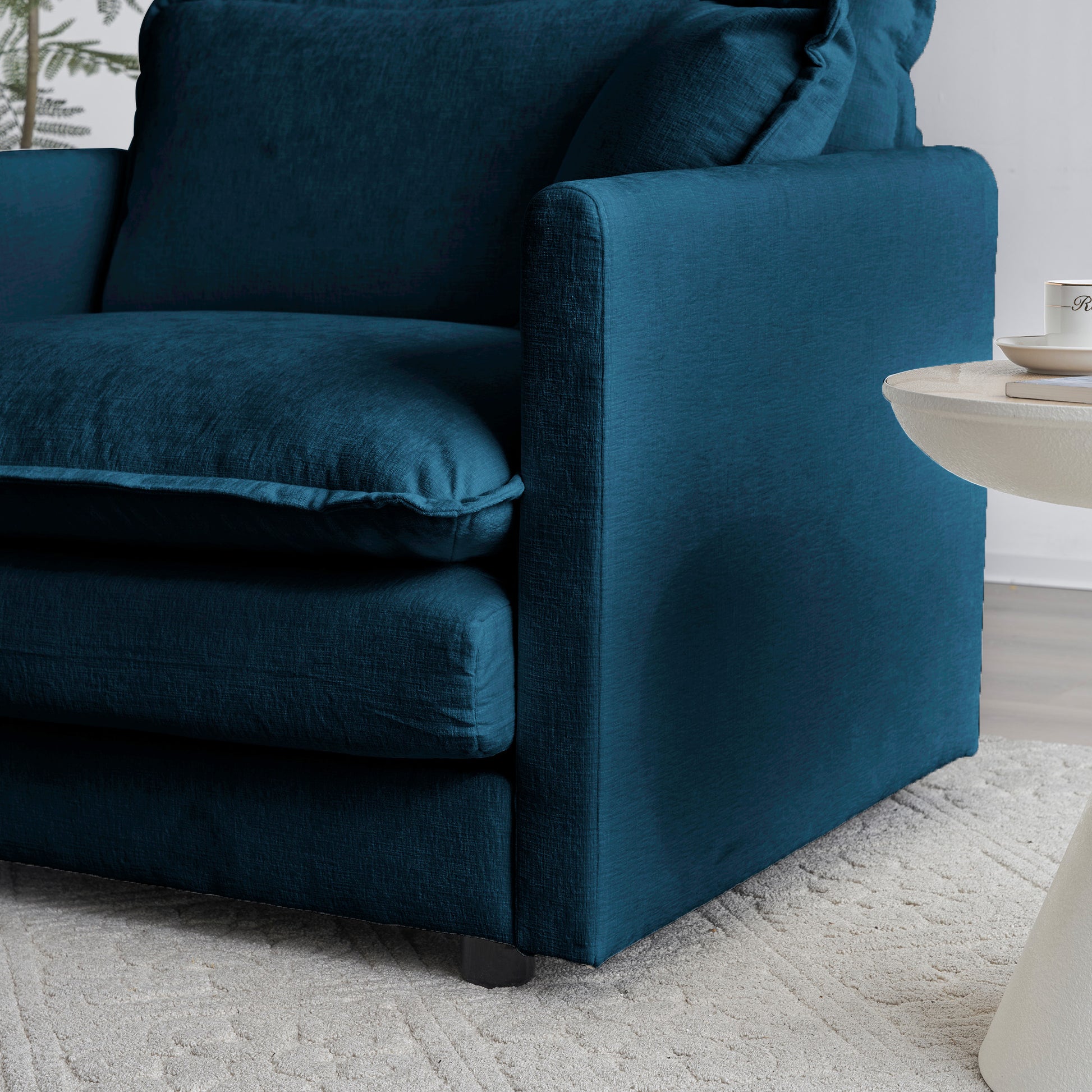 Deep teal linen armchair with plush cushions perfect for a cozy living room