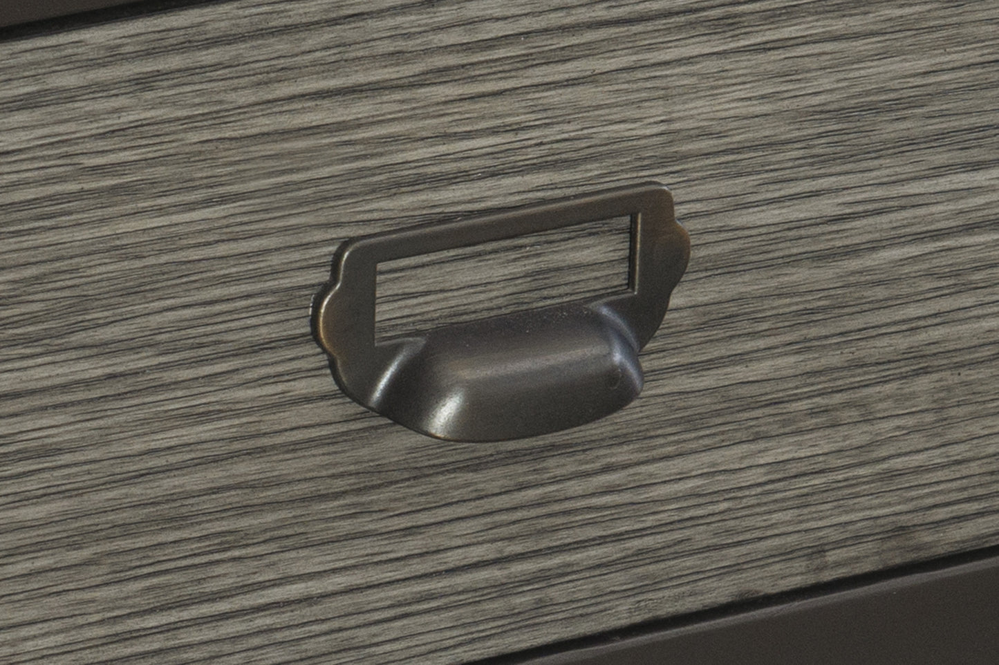 Rustic metal drawer pull on grey wood grain