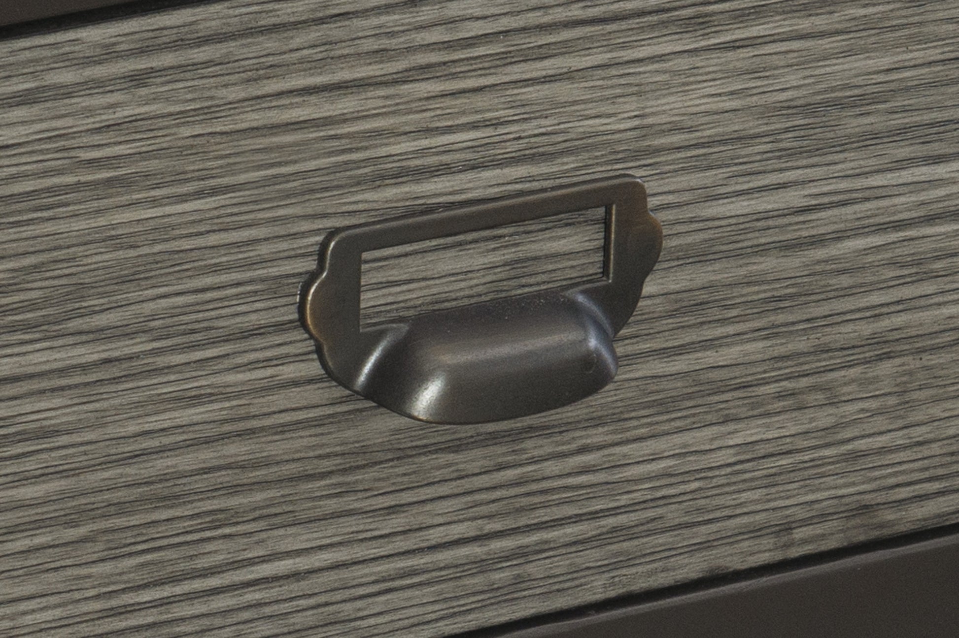 Rustic metal drawer pull on grey wood grain