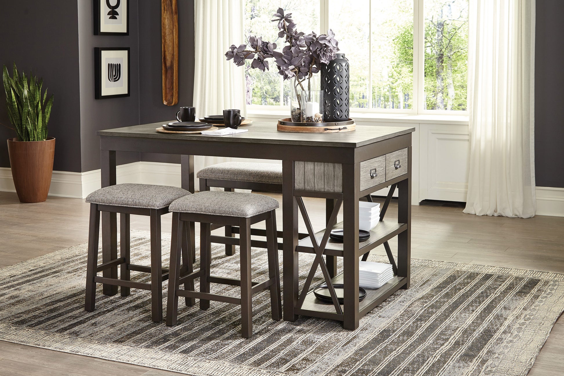 Gray upholstered counter stools at a dark wood dining table with two drawers