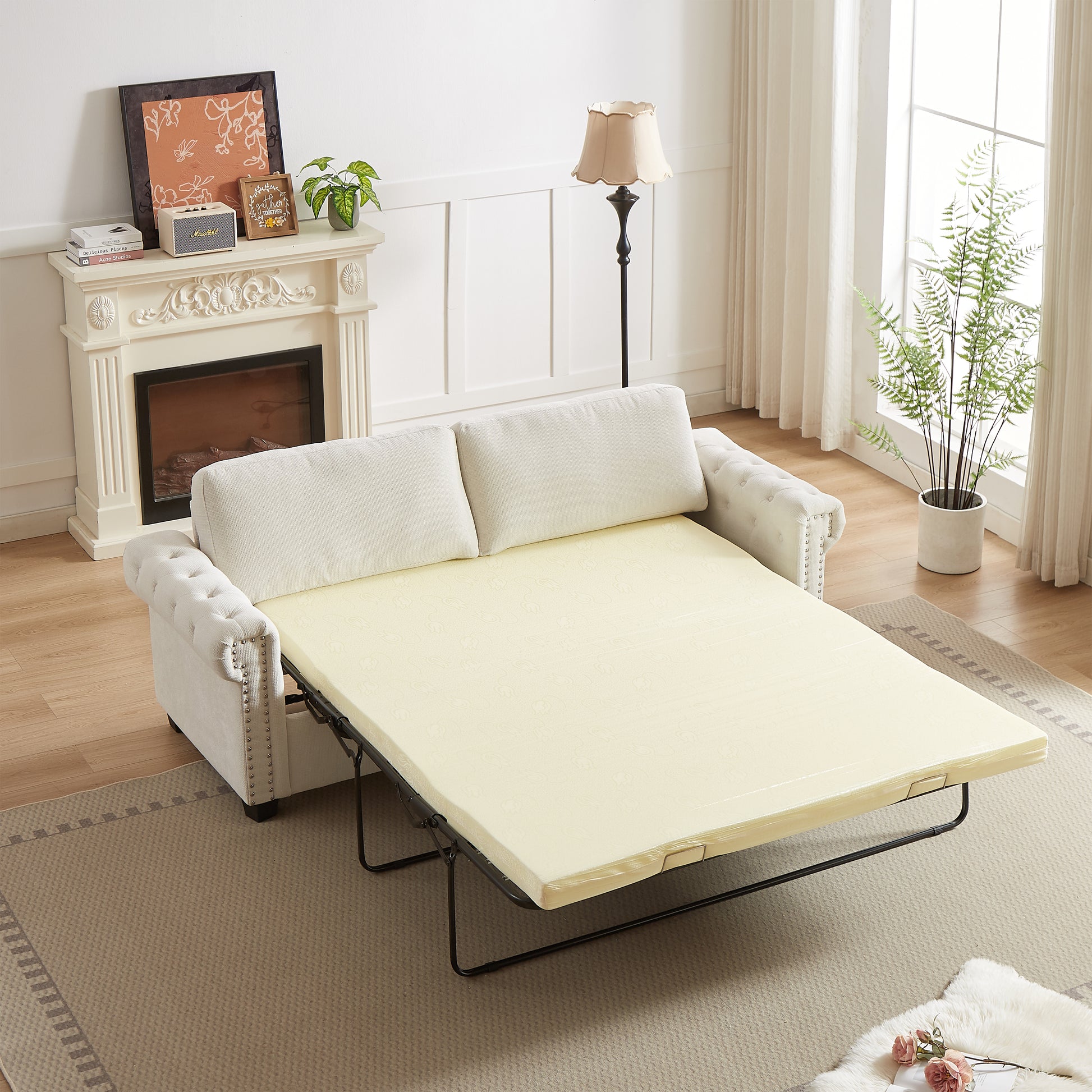 White chesterfield sofa bed fully extended with plush cream cushions and silver studding