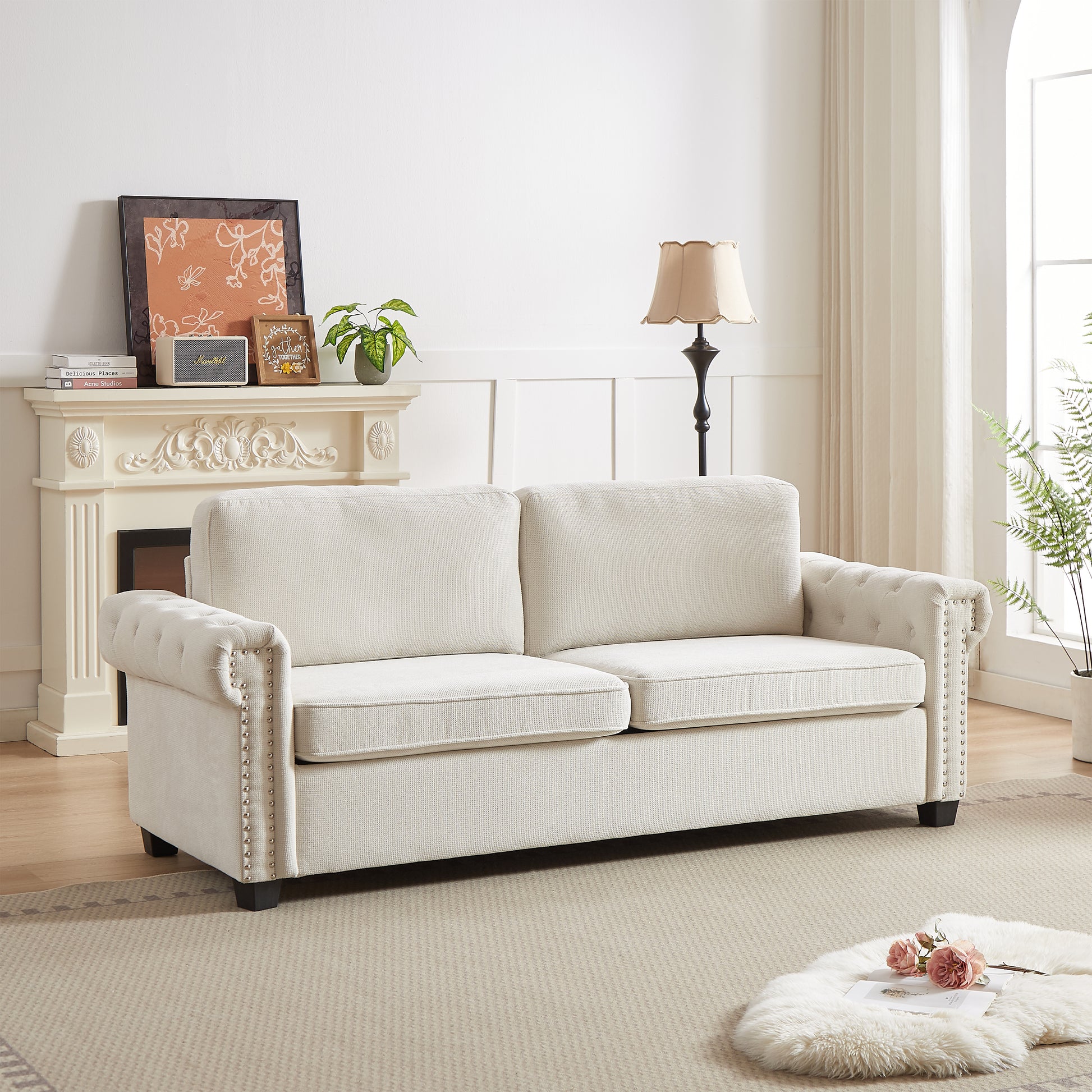 Elegant cream tufted chesterfield sofa with silver nailhead trim for a luxurious living room