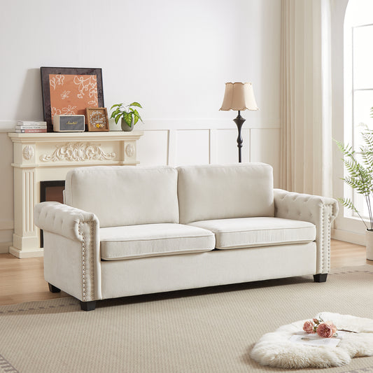 Elegant cream tufted chesterfield sofa with silver nailhead trim for a luxurious living room