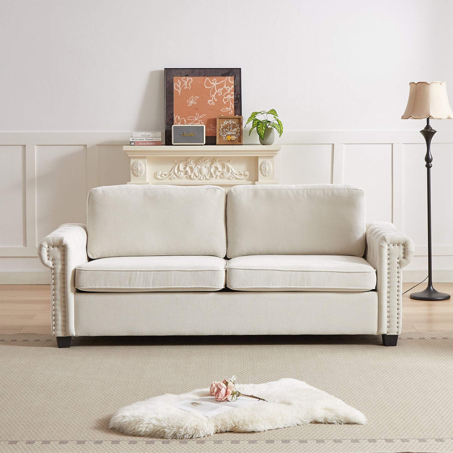 Cream upholstered sofa with studded arms and plush cushions perfect for living rooms