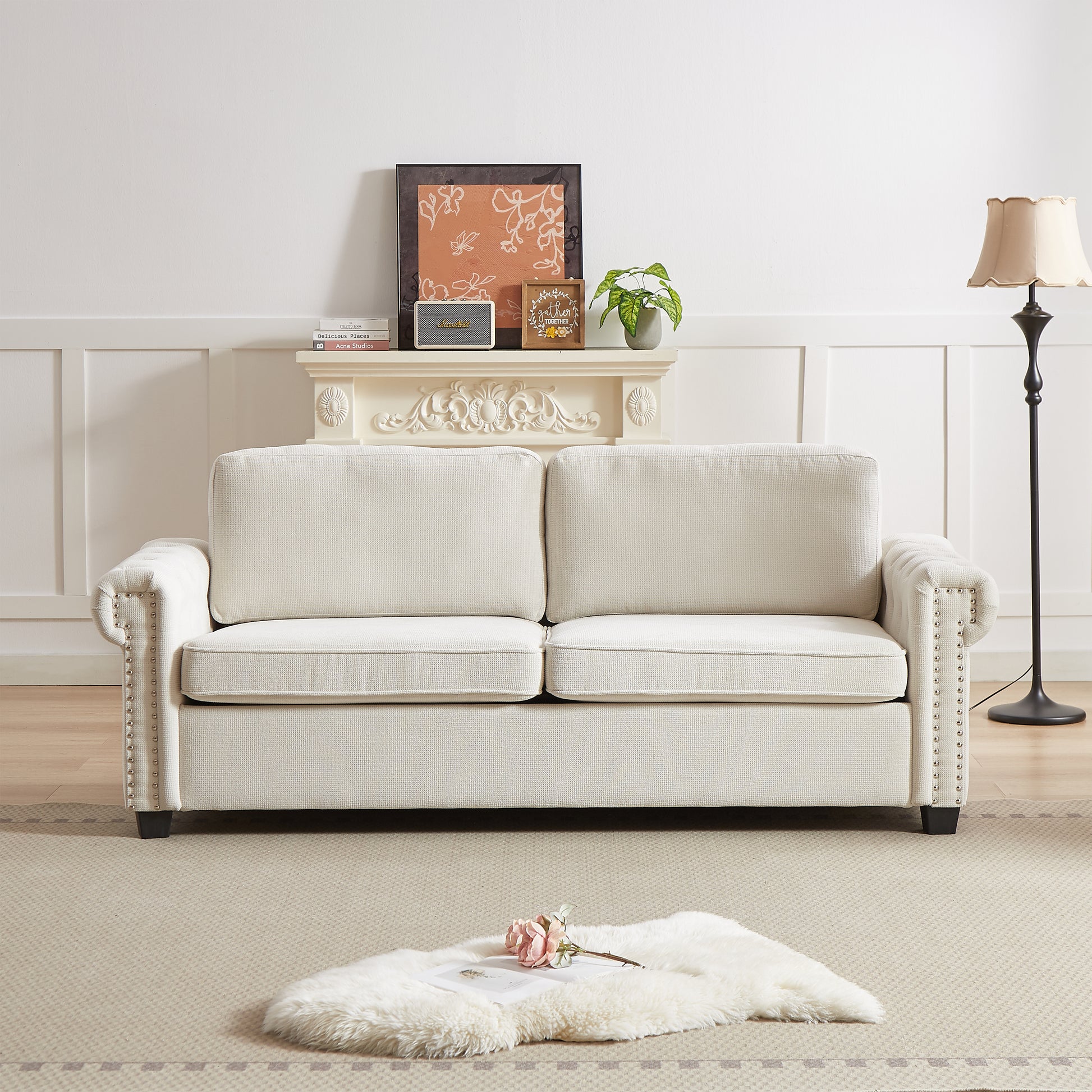 Cream upholstered sofa with studded arms and plush cushions perfect for living rooms