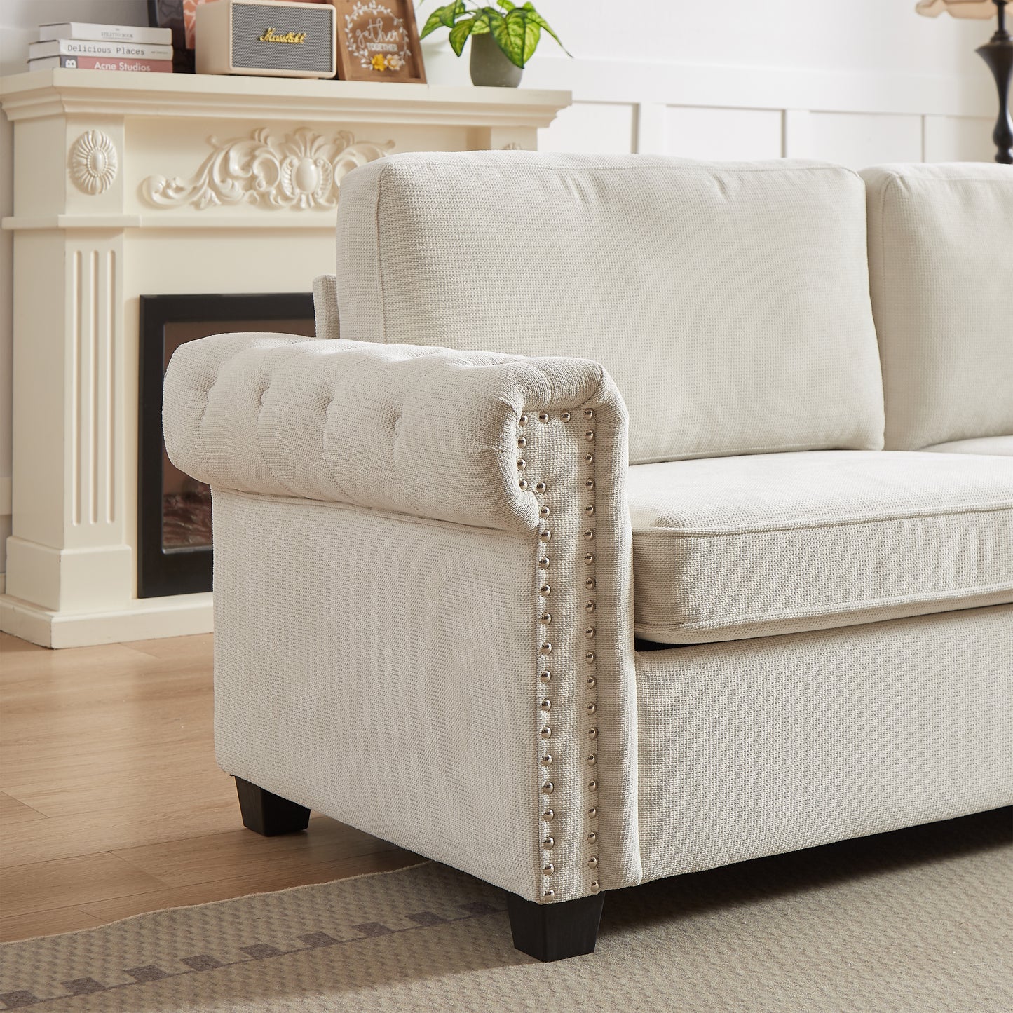 Cream linen chesterfield sofa with tufted armrests and silver nailhead trim
