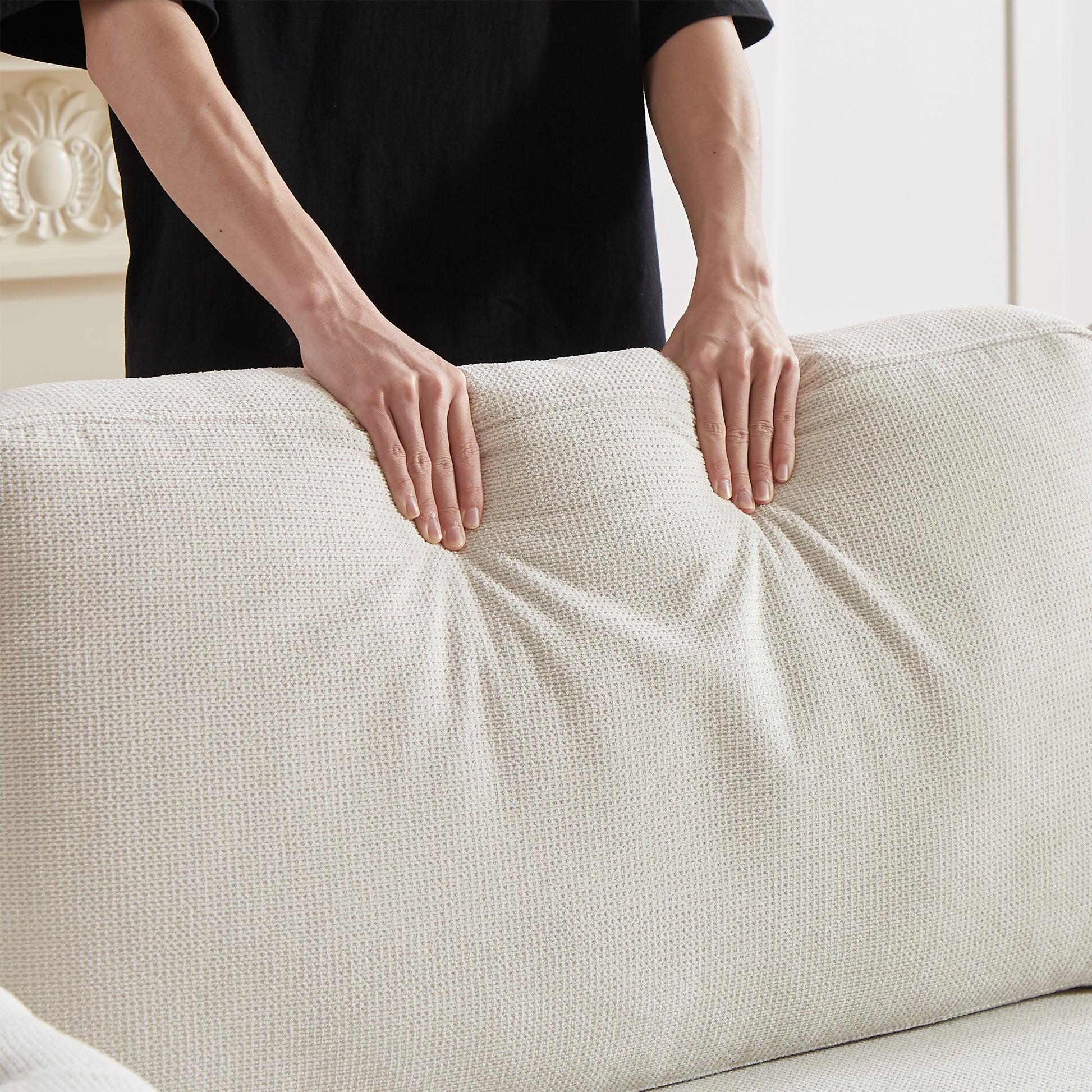 Closeup of textured beige sofa cushion fabric being tested for durability