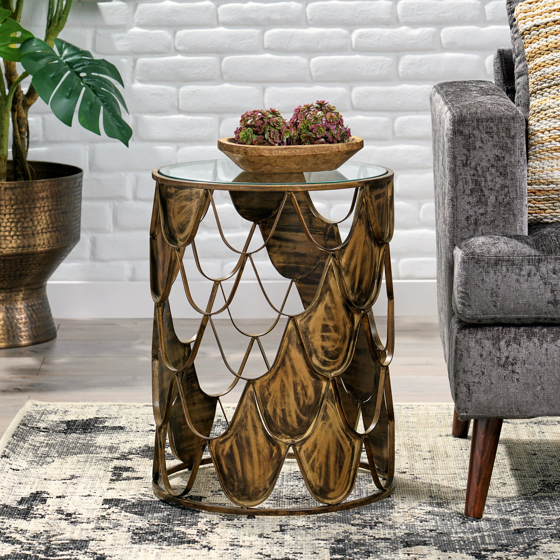 Antique gold metal side table with glass top and scalelike base