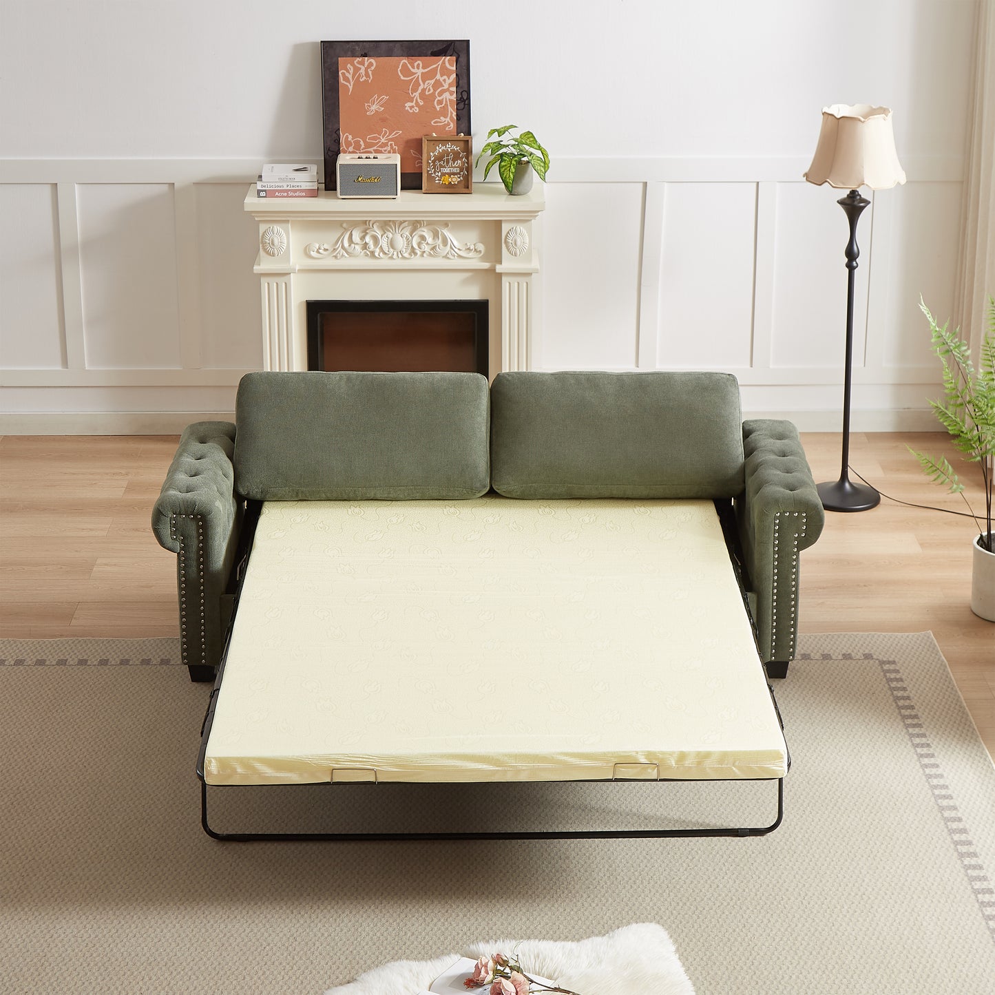 Green upholstered sofa bed with tufted arms and pullout mattress frame