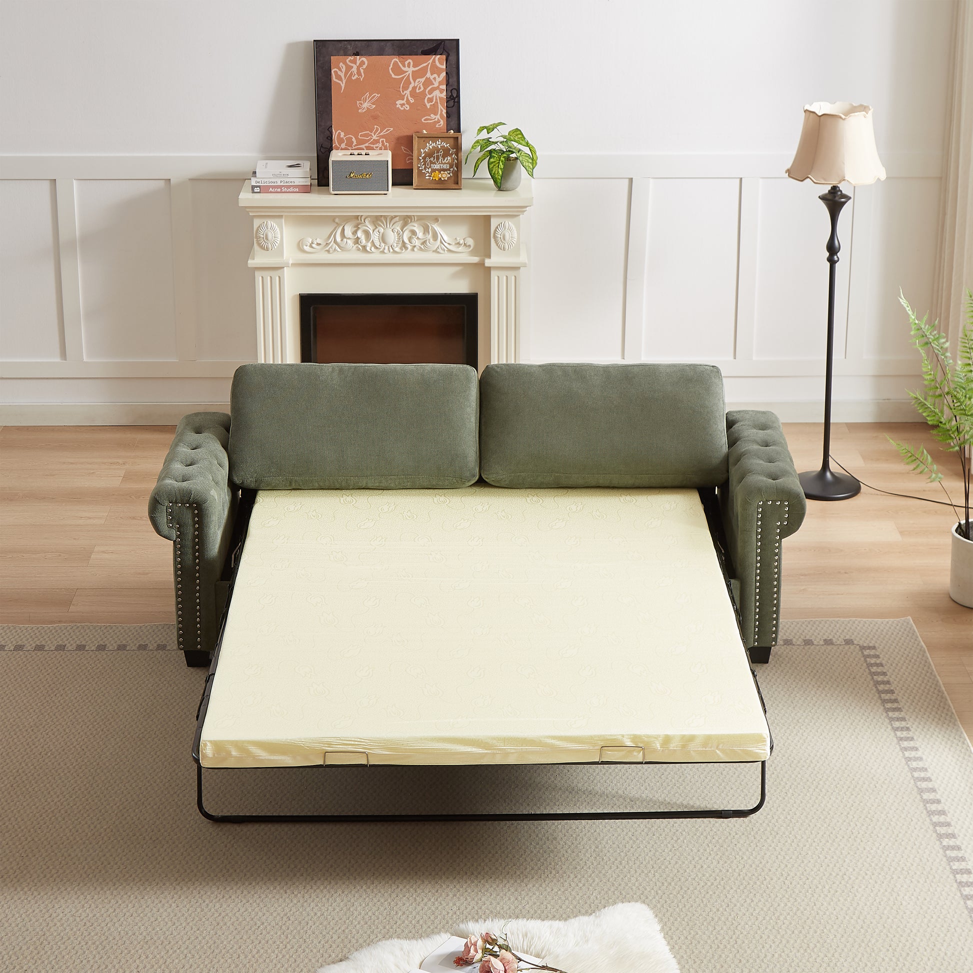 Green upholstered sofa bed with tufted arms and pullout mattress frame