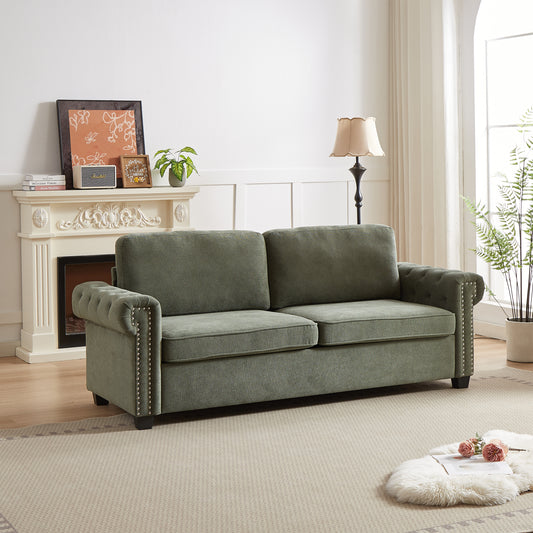 Elegant tufted sage green sofa with silver nailhead trim and plush cushions