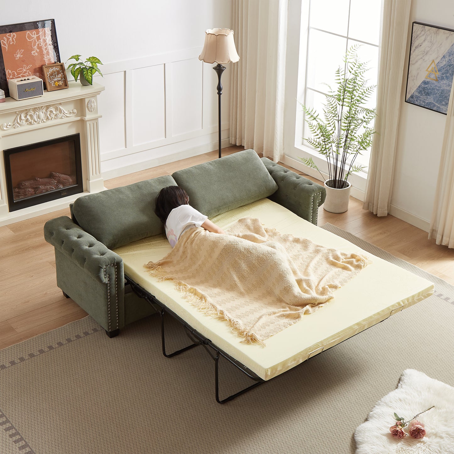 Green velvet sleeper sofa with tufted arms and studded trim featuring a pullout bed
