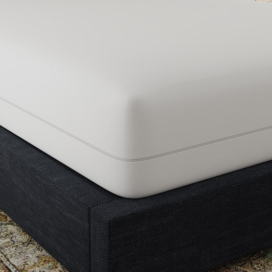 Closeup of a white mattress with a grey zipper detail resting on a dark grey textured bed base