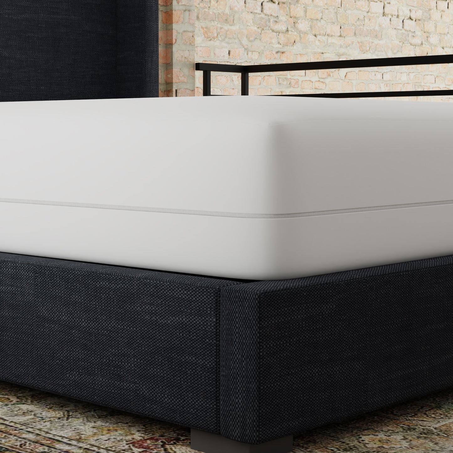 Dark grey upholstered bed frame with a crisp white mattress brick wall background