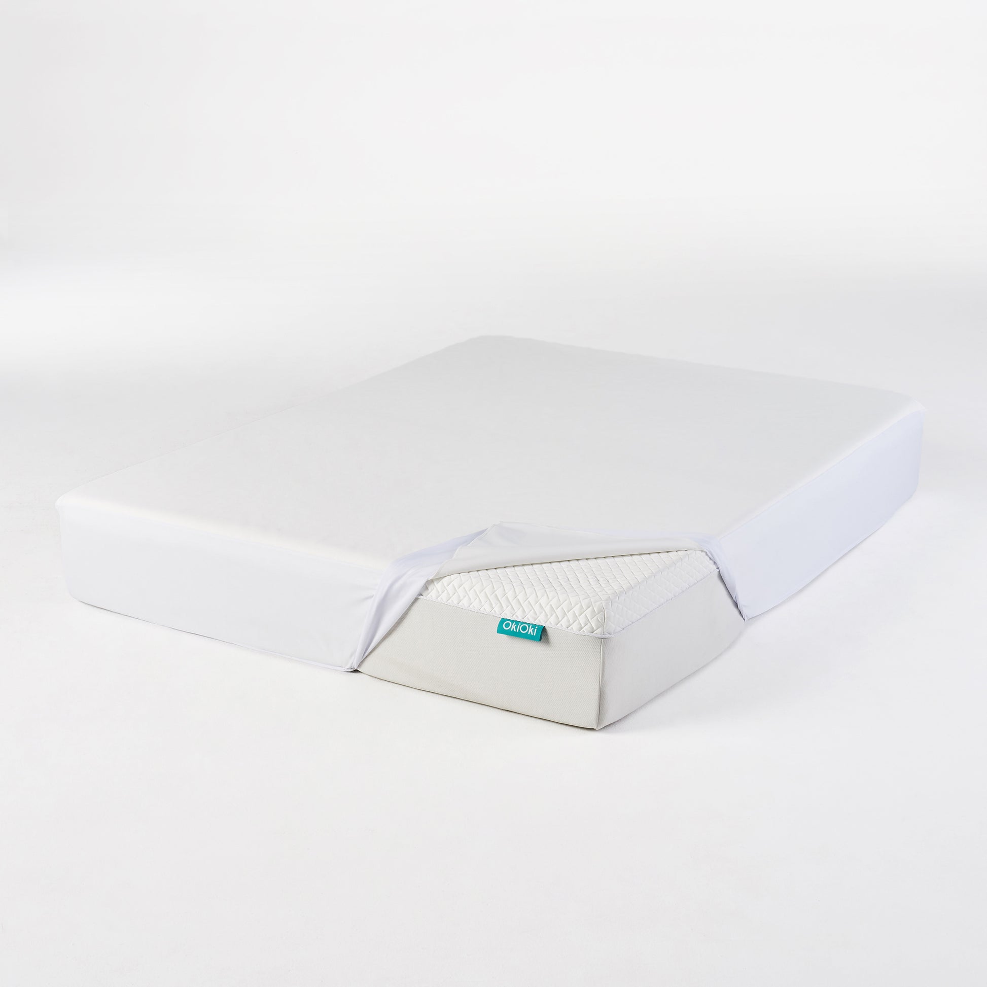 White mattress with a light grey base and a diamondstitched top layer showing a portion of its quilted mattress surface
