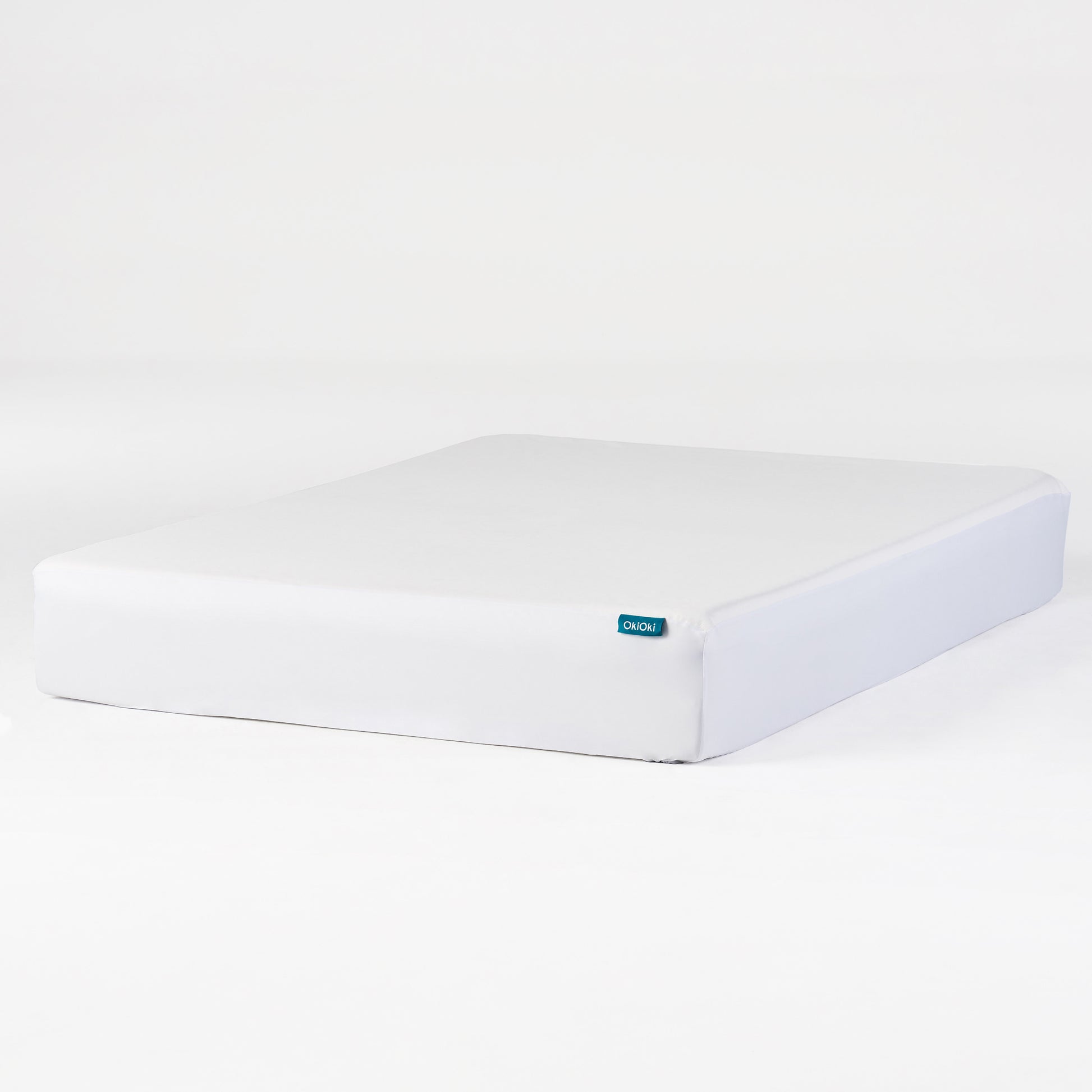 White OkiOki mattress with a teal logo tag ideal for comfortable sleep