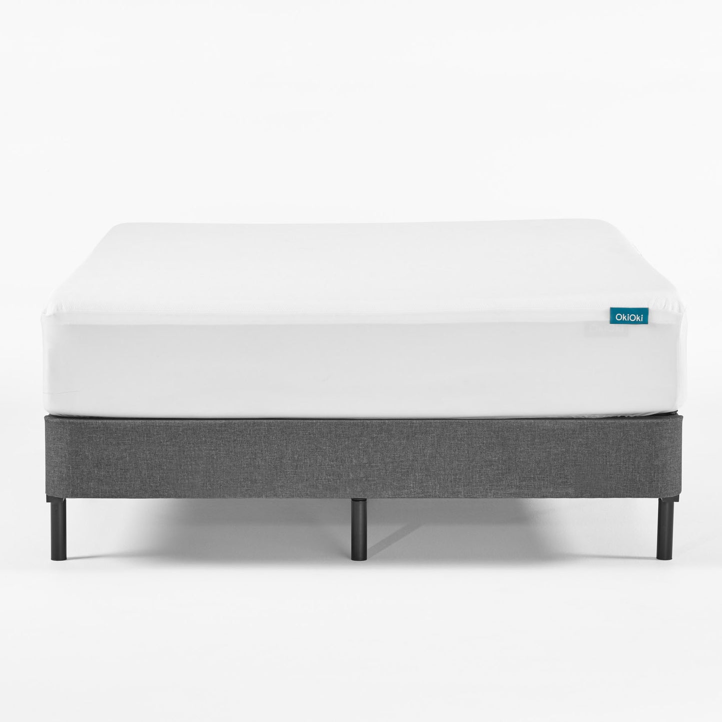 White fitted sheet on grey upholstered bed frame with black legs