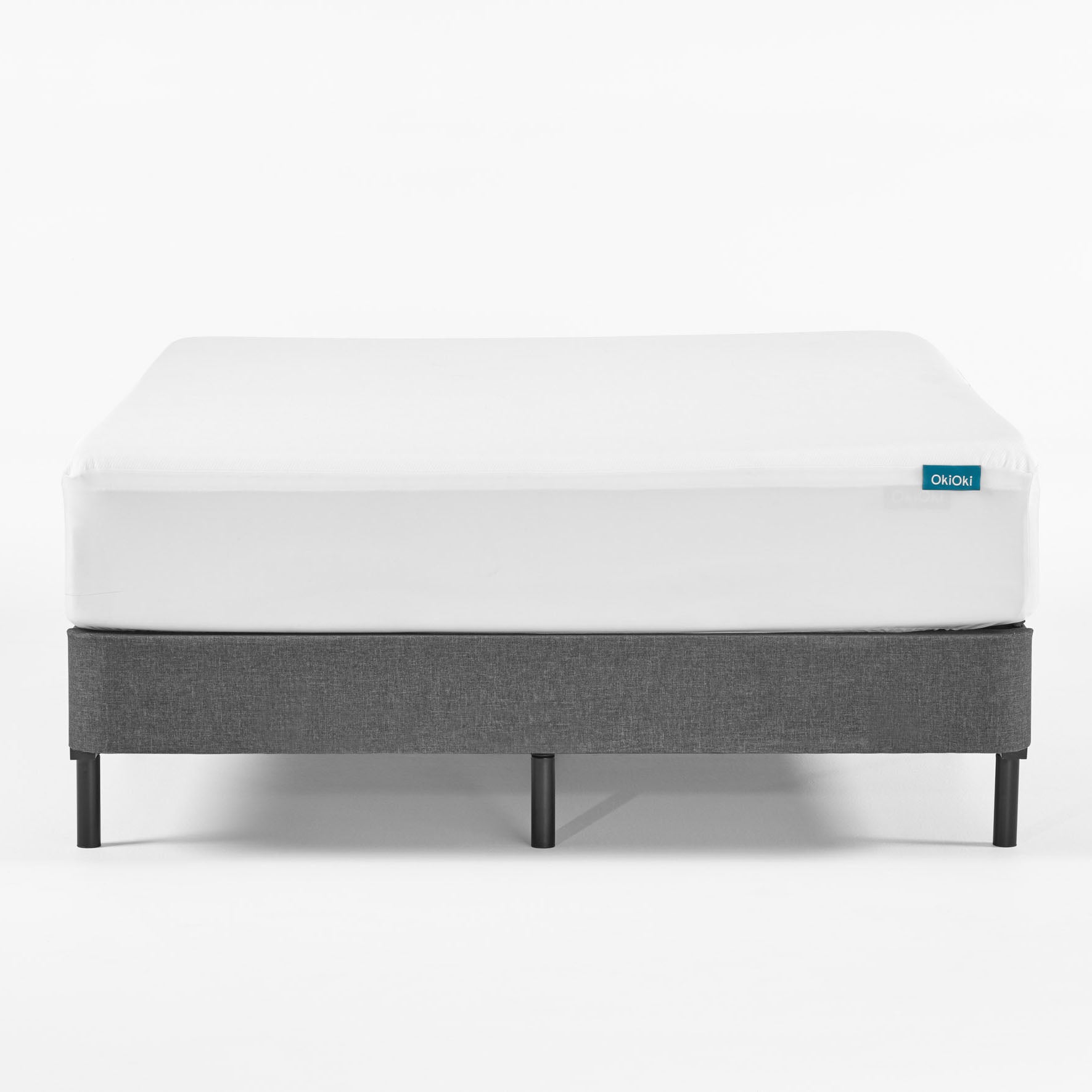 White fitted sheet on grey upholstered bed frame with black legs